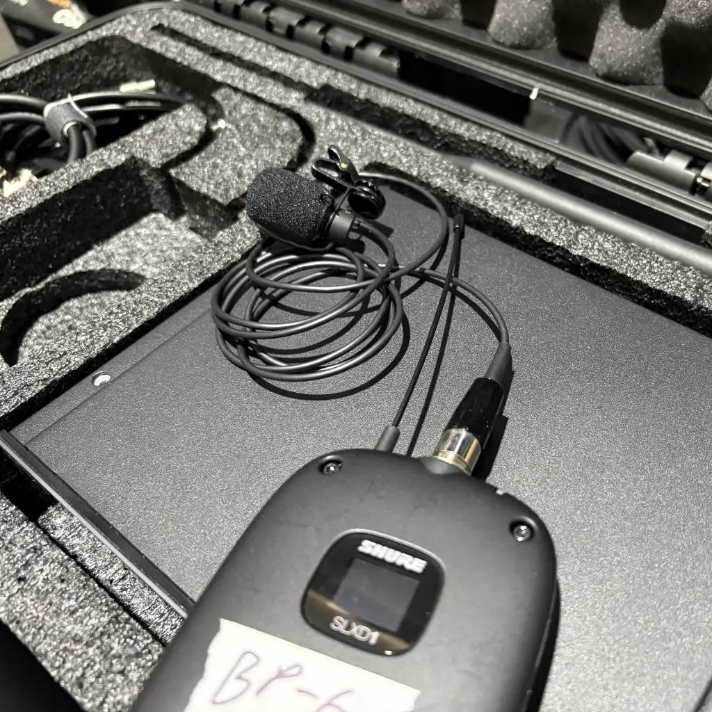 Shure bodypack transmitter connected to lavalier microphone showing complete wireless audio setup
