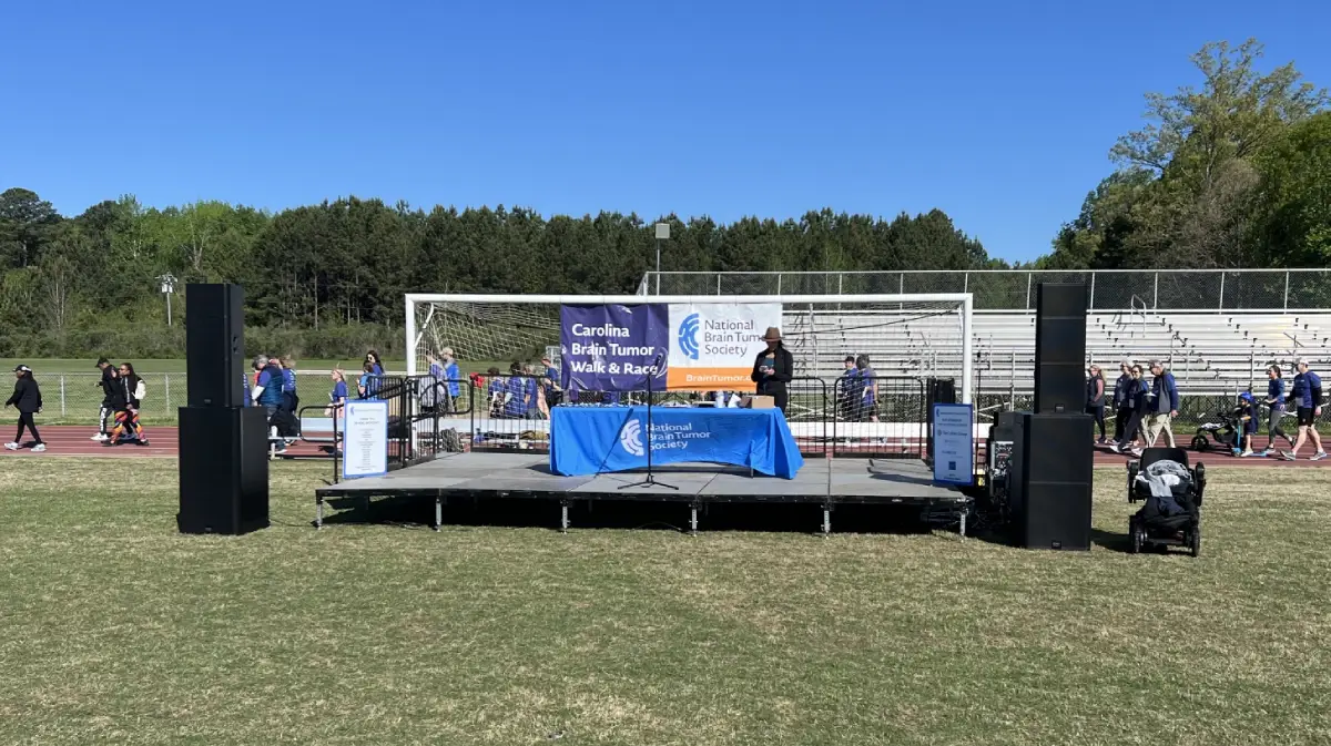 Professional audio speaker towers on outdoor stage showing commercial sound system installation