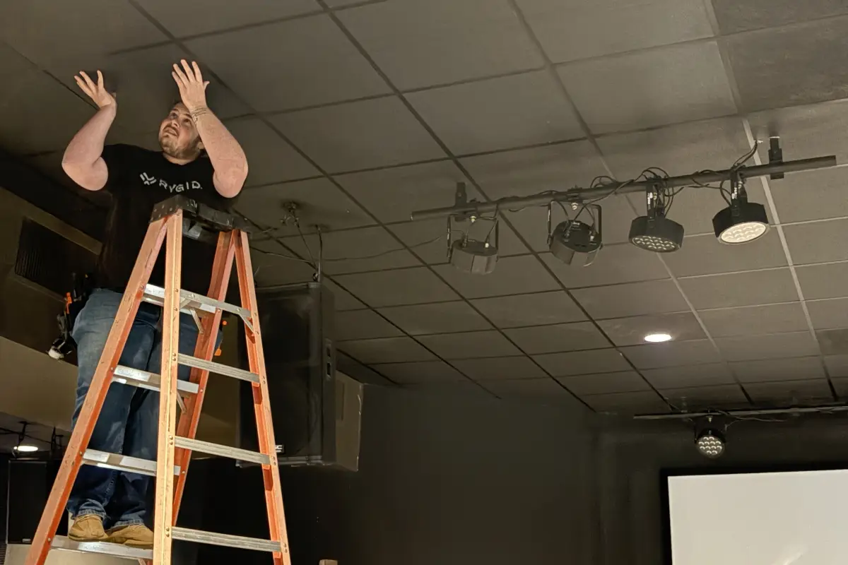 RYGID AV technician installing platform lighting fixtures in a church worship space