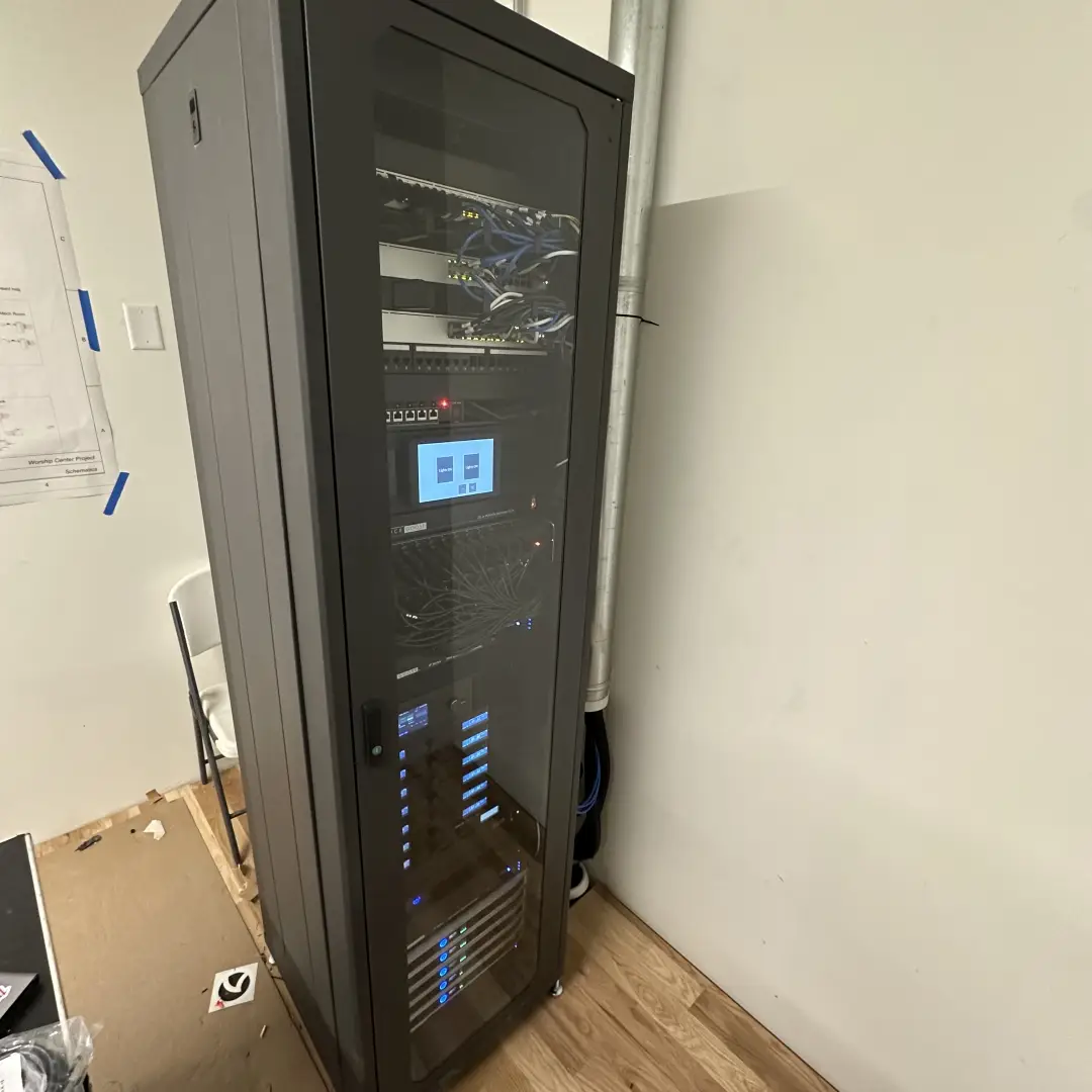 Commercial AV equipment rack installed in an enclosed space showing network and control systems