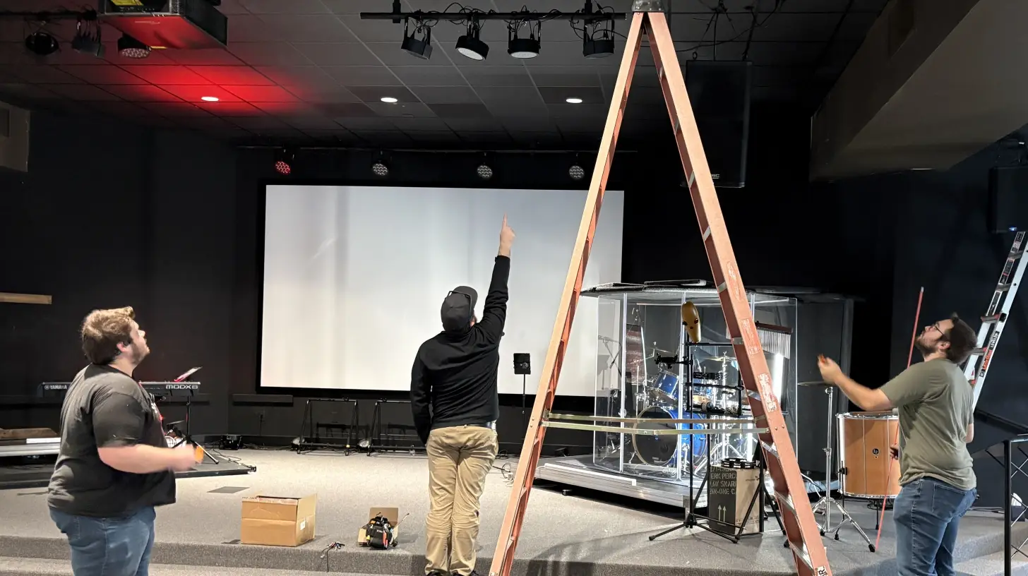 RYGID AV team inspecting ceiling-mounted equipment in a church sanctuary during a service visit