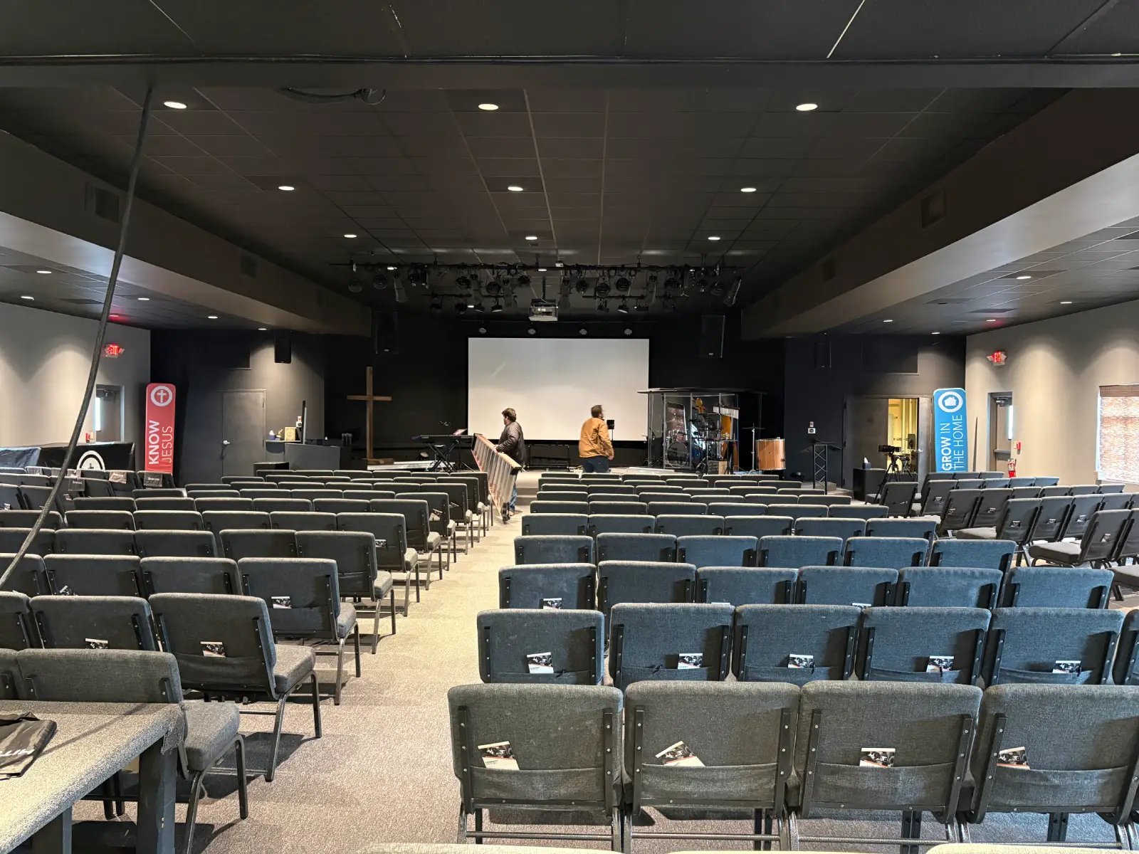 Contemporary church worship space with theater seating and front projection screen