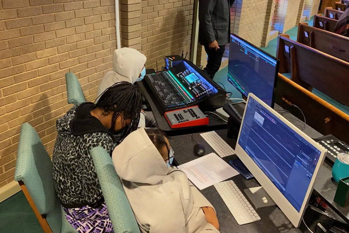 Church volunteers operating a digital sound mixer during a service