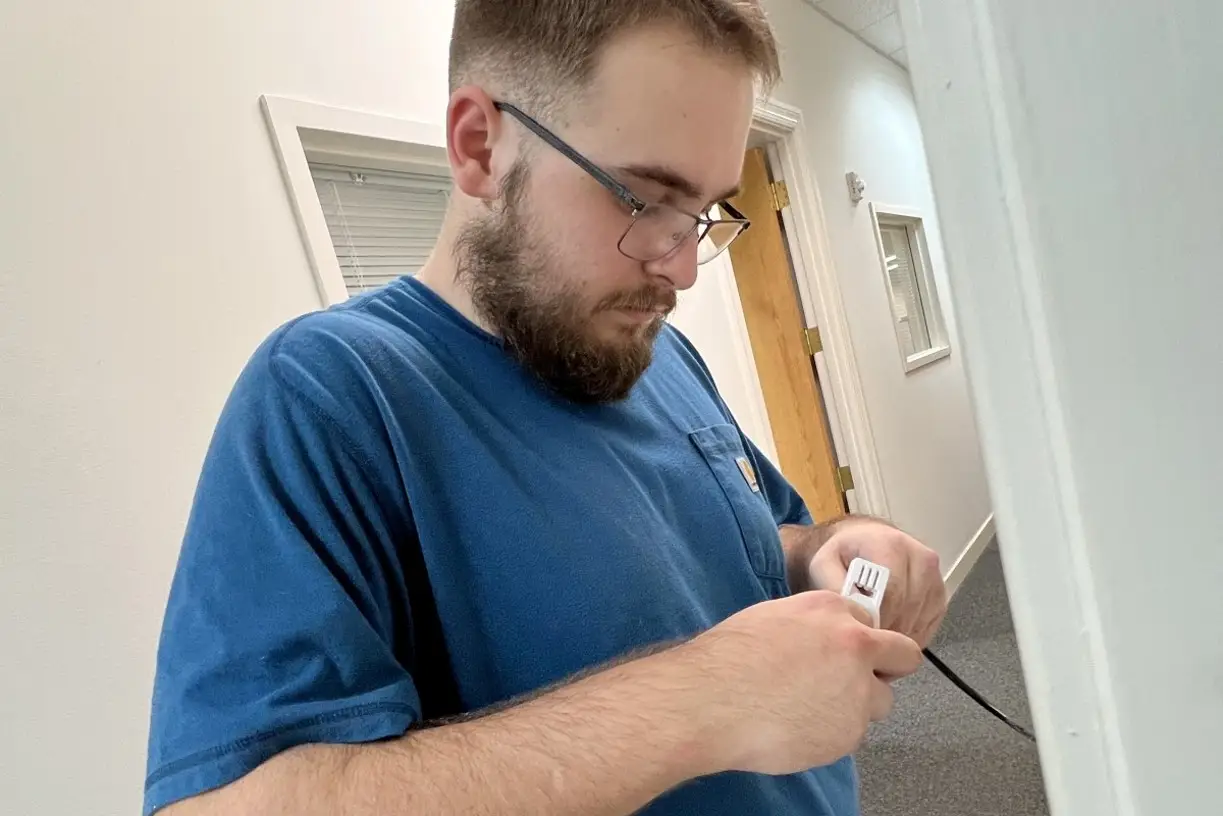 RYGID AV technician terminating a cable connection during a project walkthrough