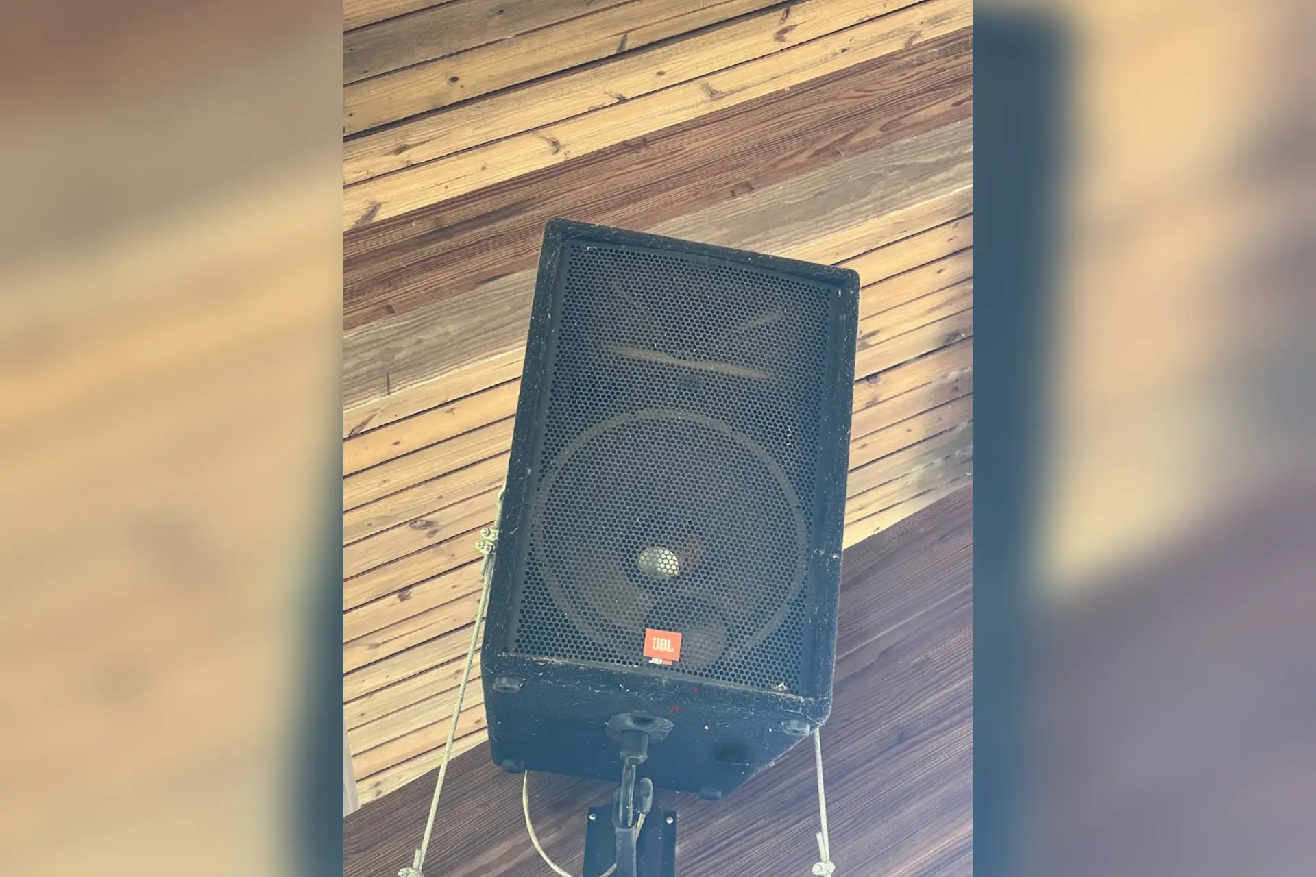 A worn PA speaker cabinet inspected on-site, later found to have drivers torn behind the grille