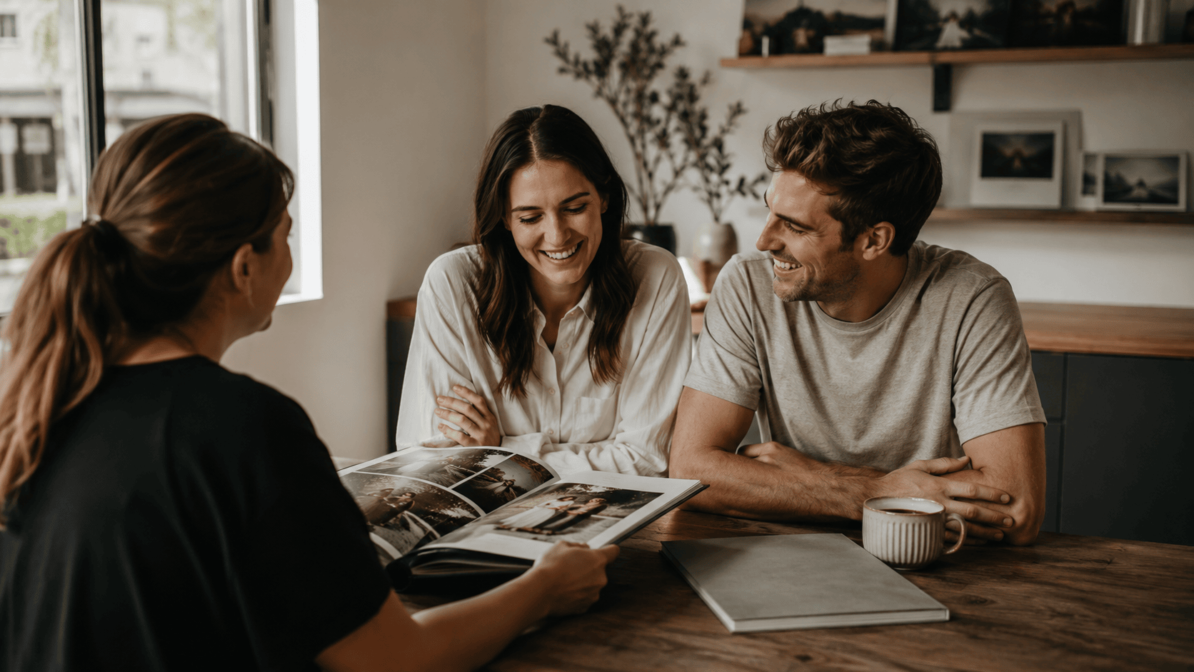 A couple reviewing a wedding photography portfolio during a consultation with their photographer