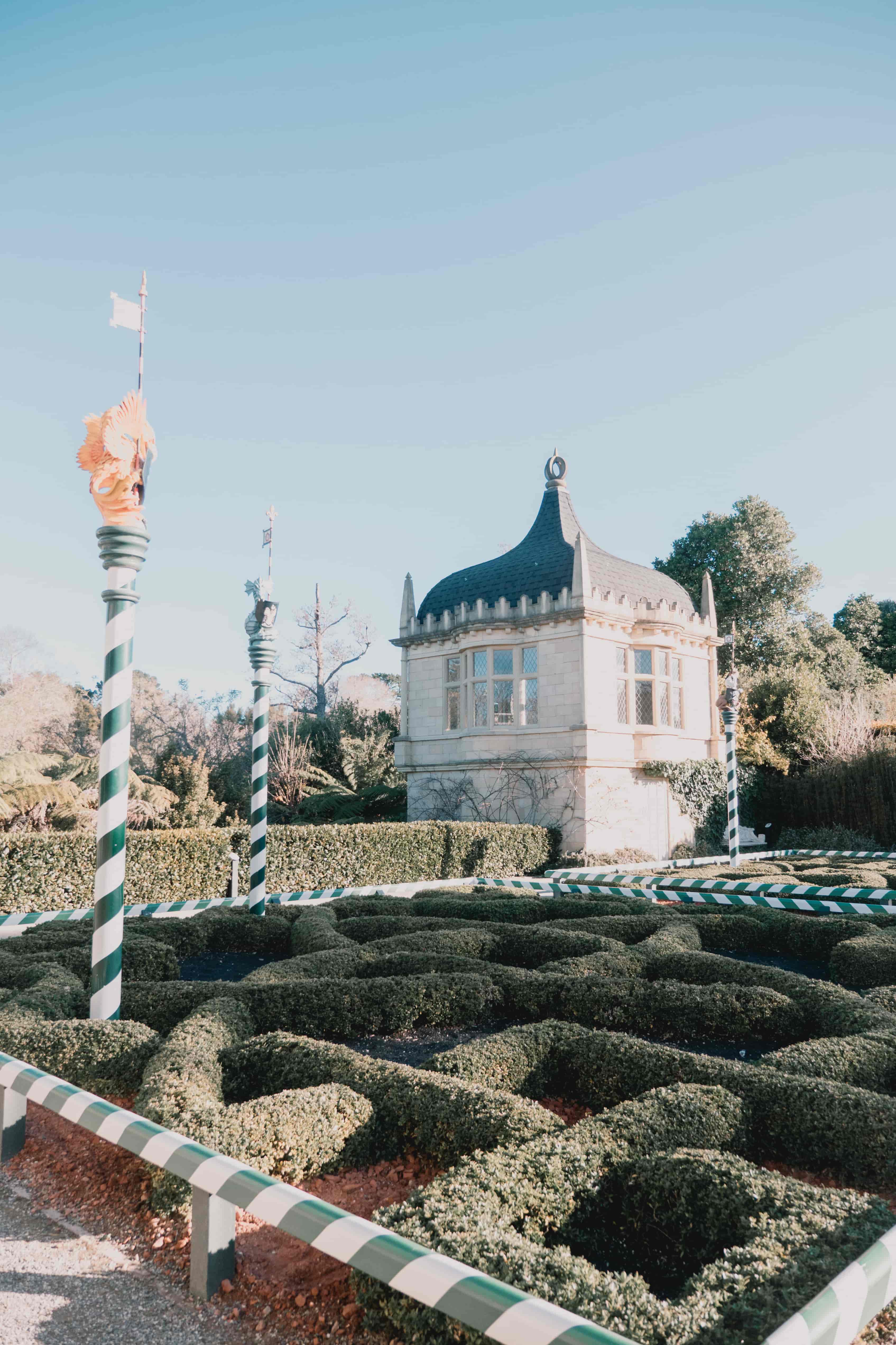 Clipped knot garden hedges with striped poles and a domed white pavilion beyond, Hamilton Gardens
