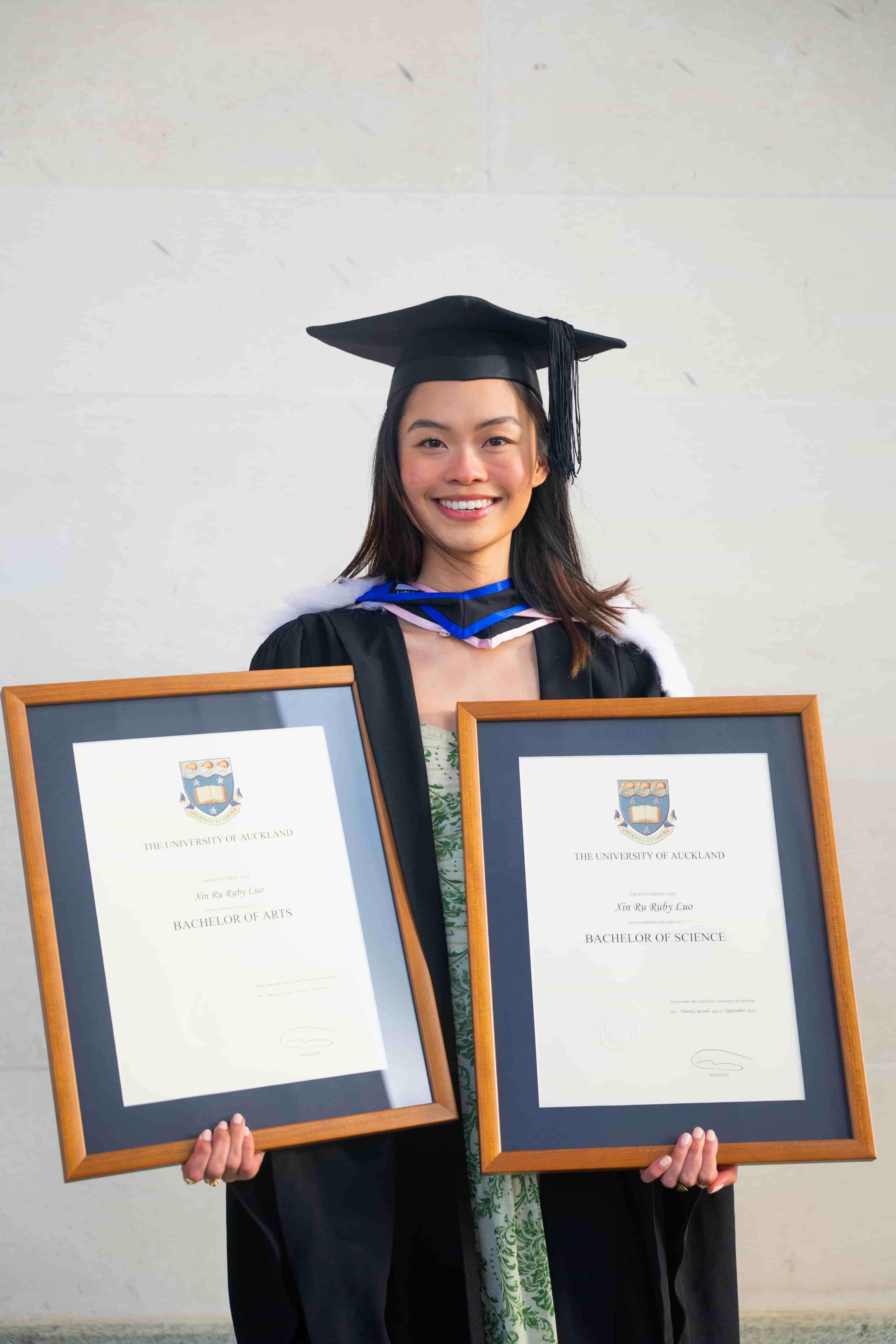 Ruby holding her framed Bachelor of Arts and Bachelor of Science degrees from the University of Auckland