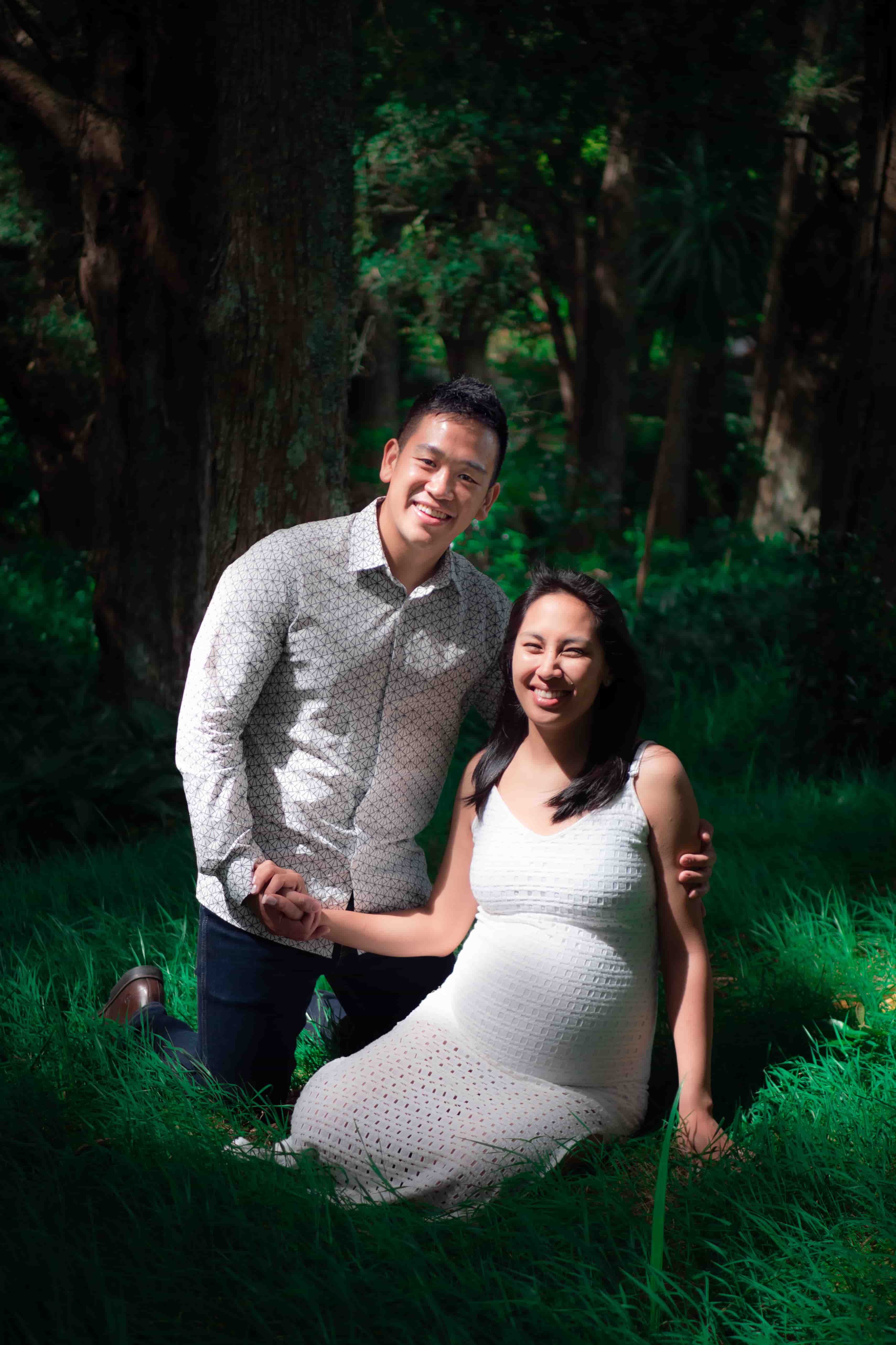 Lucas kneeling beside Elisa in the grass, both laughing
