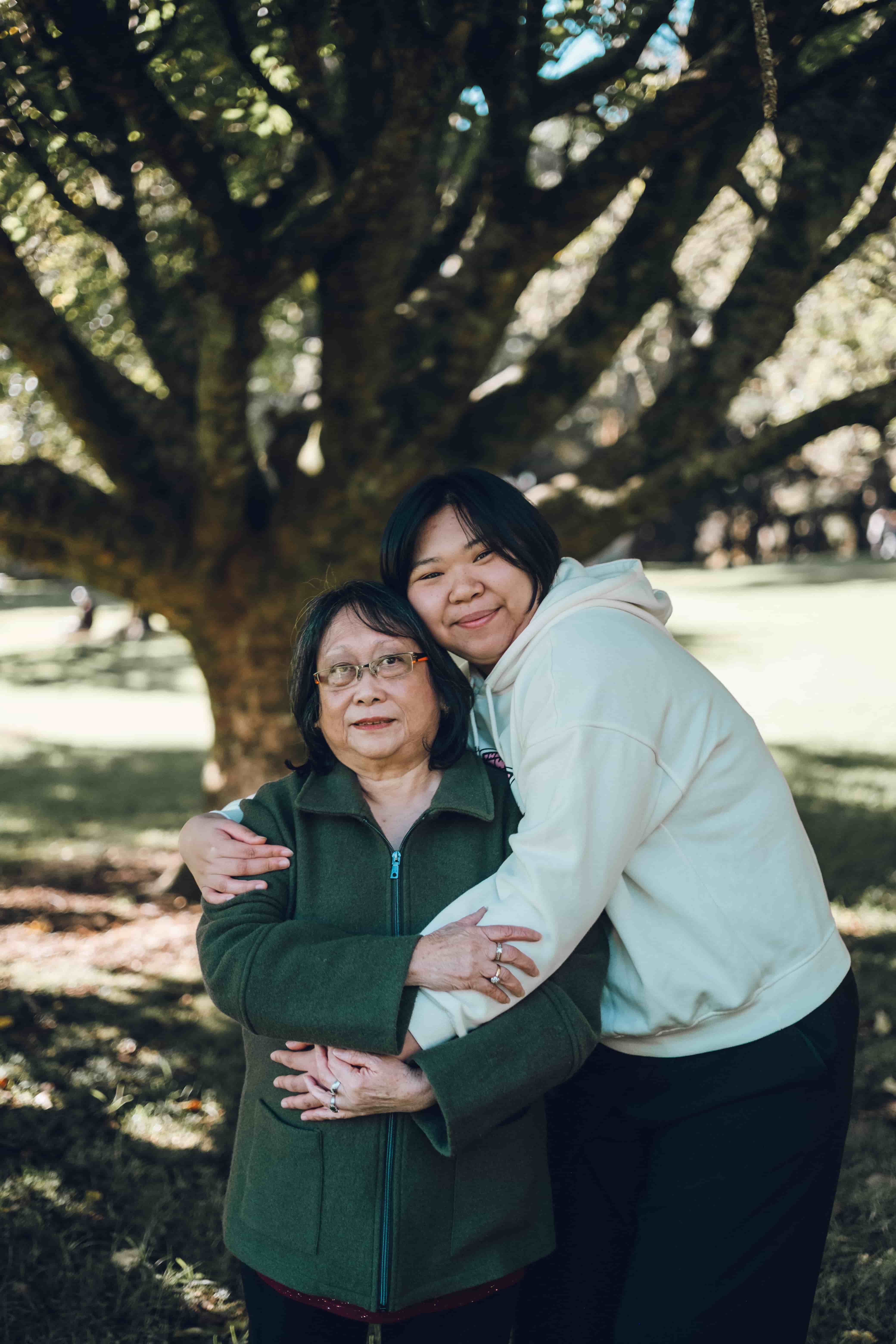 Daughter hugging her mother from behind, both smiling