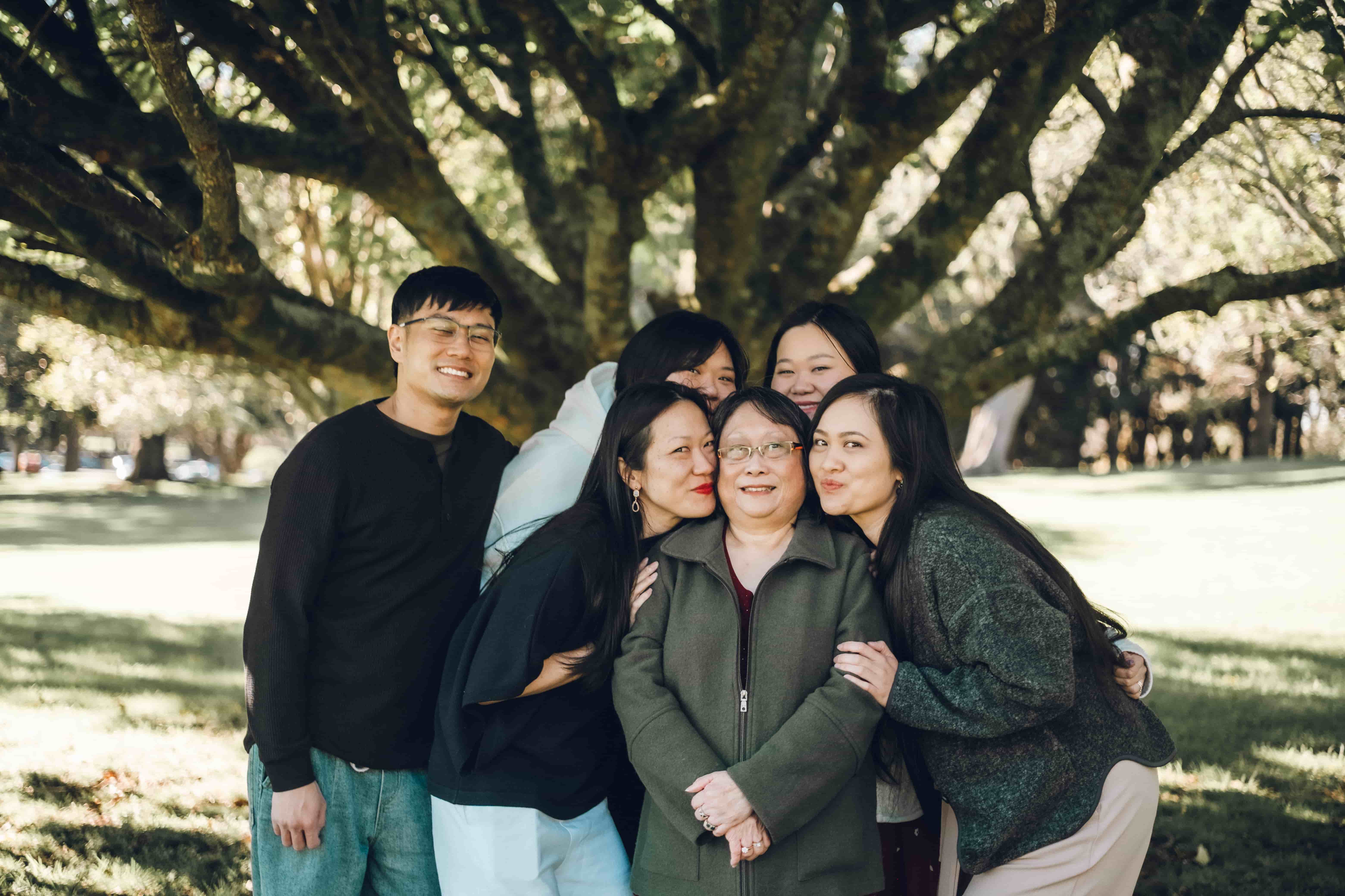 Grandmother laughing as her family leans in around her