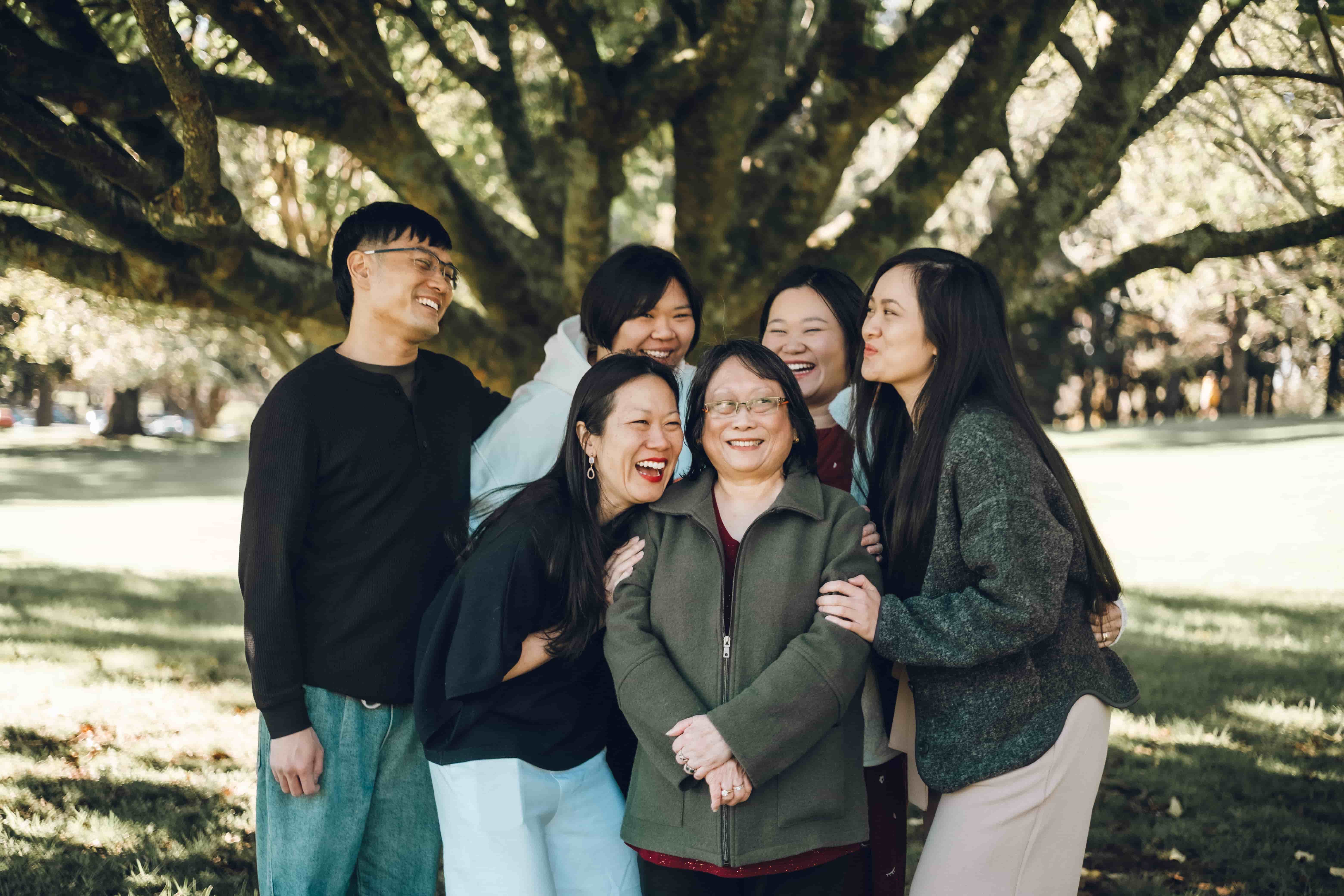 Grandmother with her adult children hugging in close