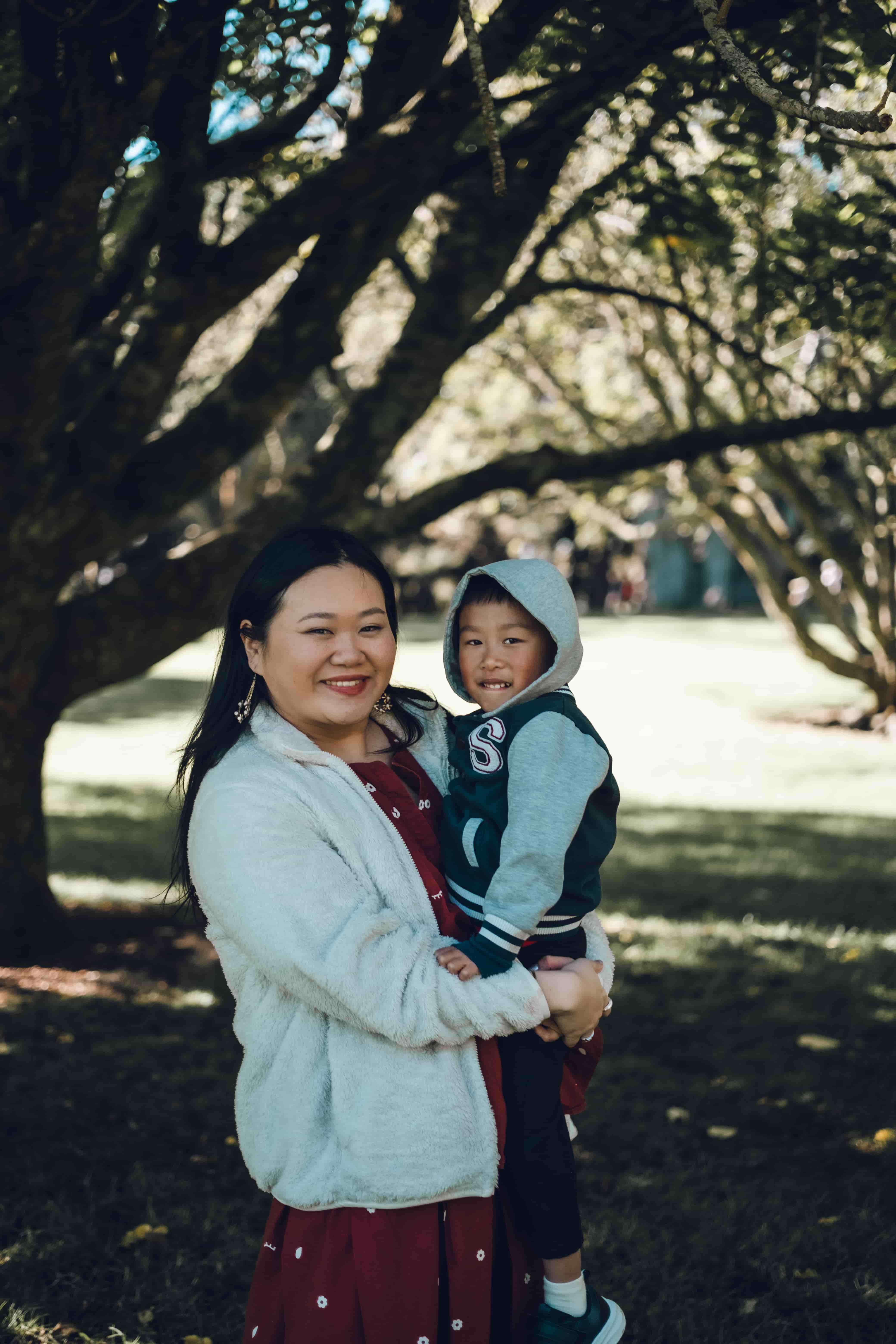 Mother holding her young son in a hooded jacket