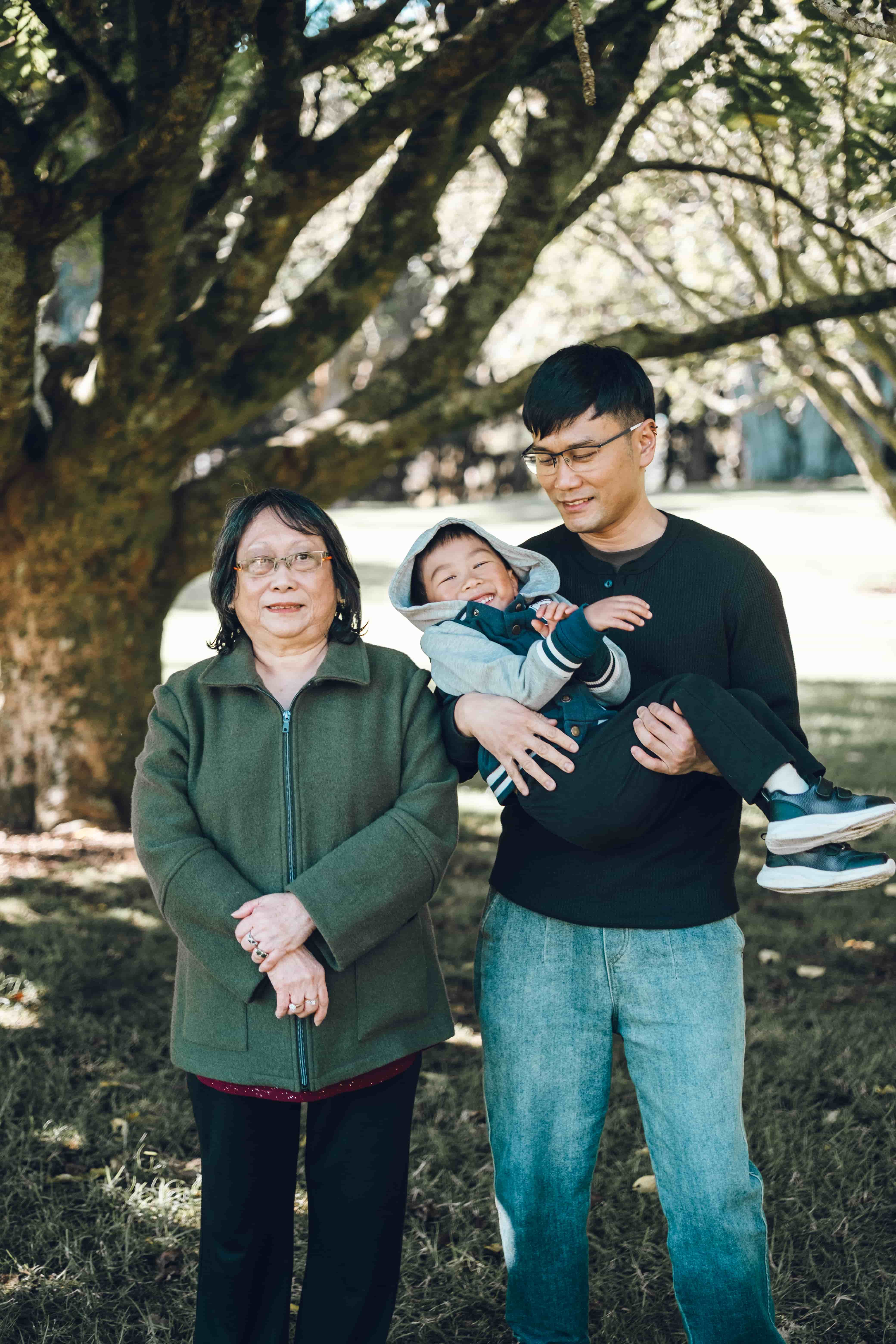 Grandmother beside her son, who is holding a toddler