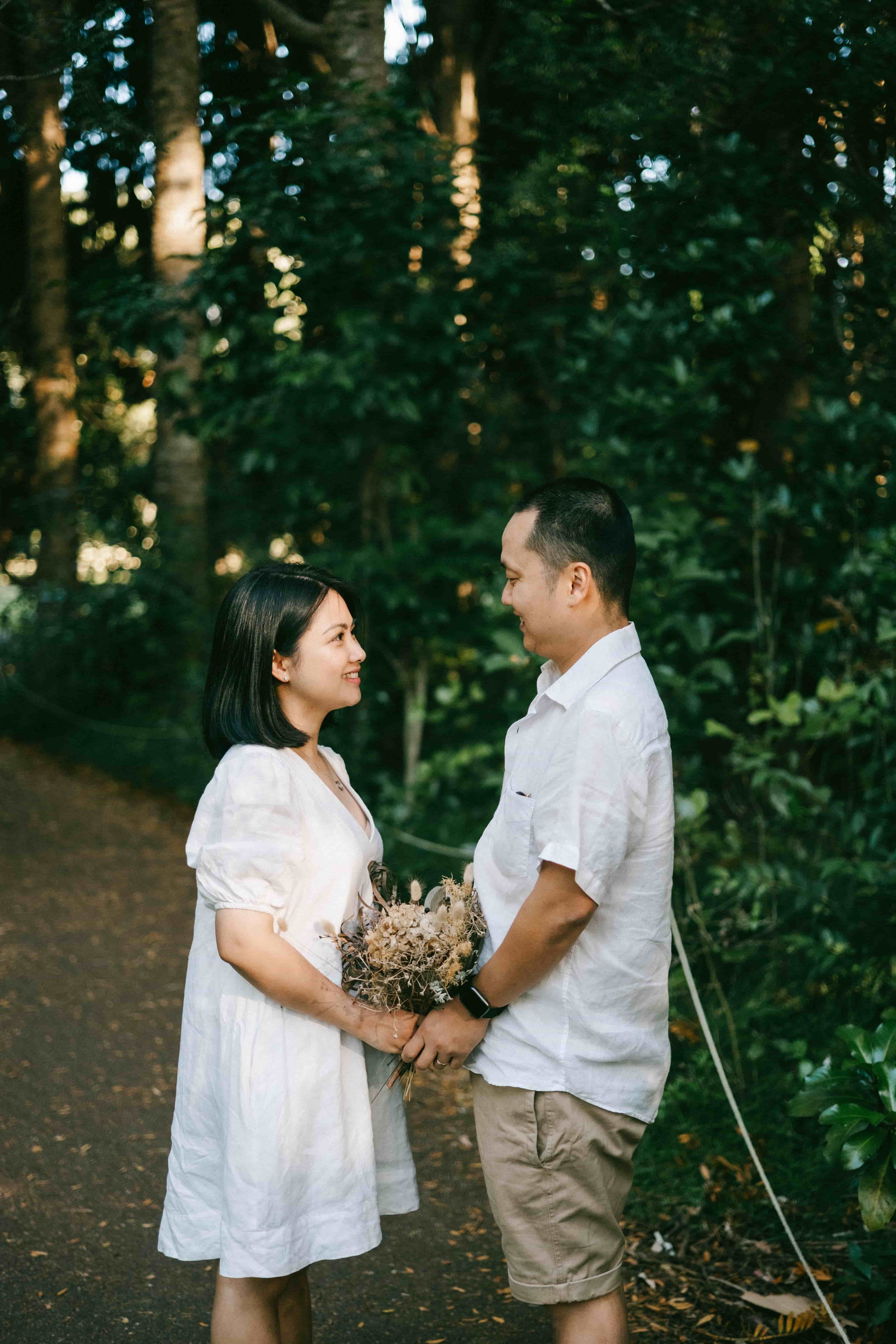 Couple facing each other and holding hands on a bush track