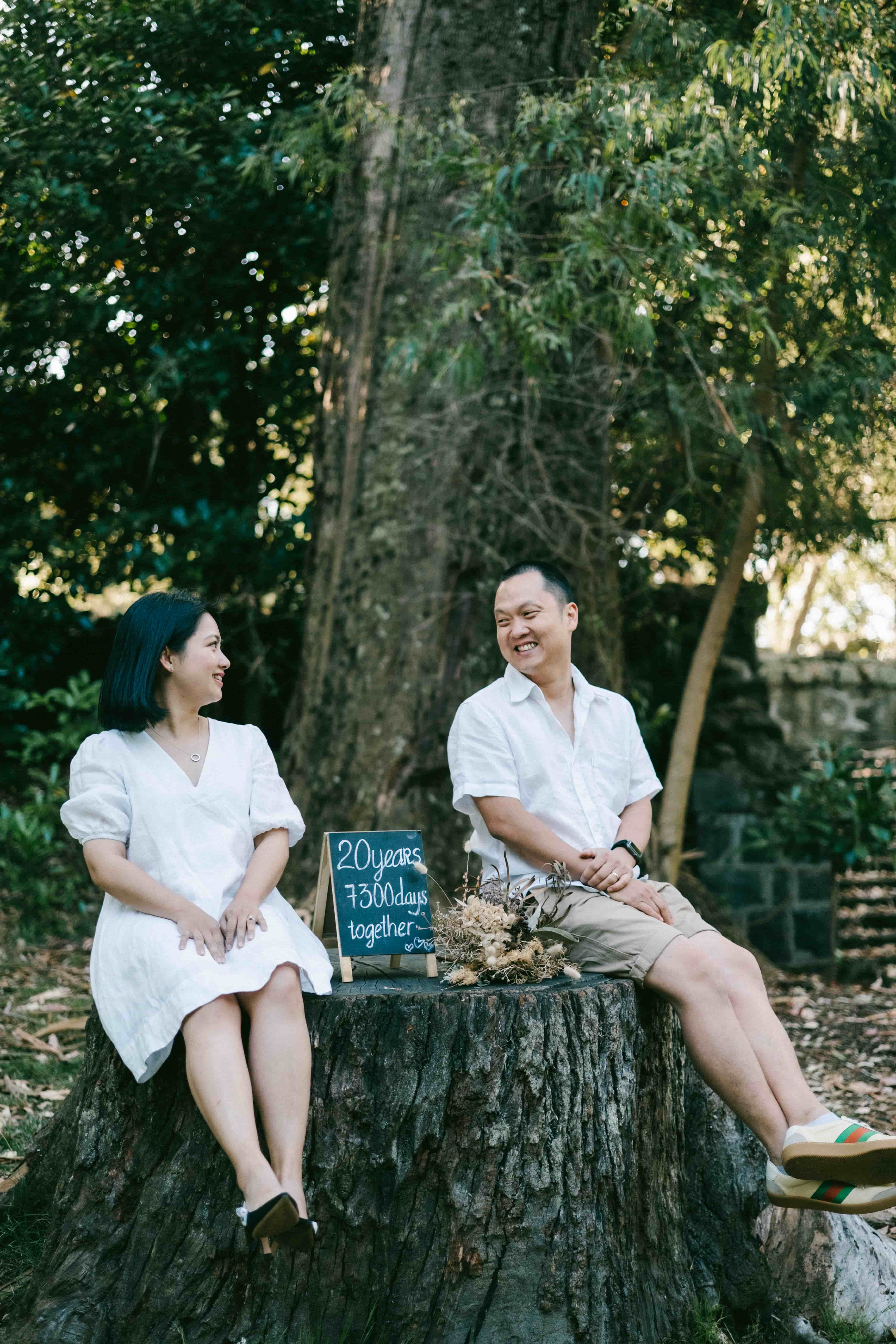 Couple sitting on a tree stump in the bush