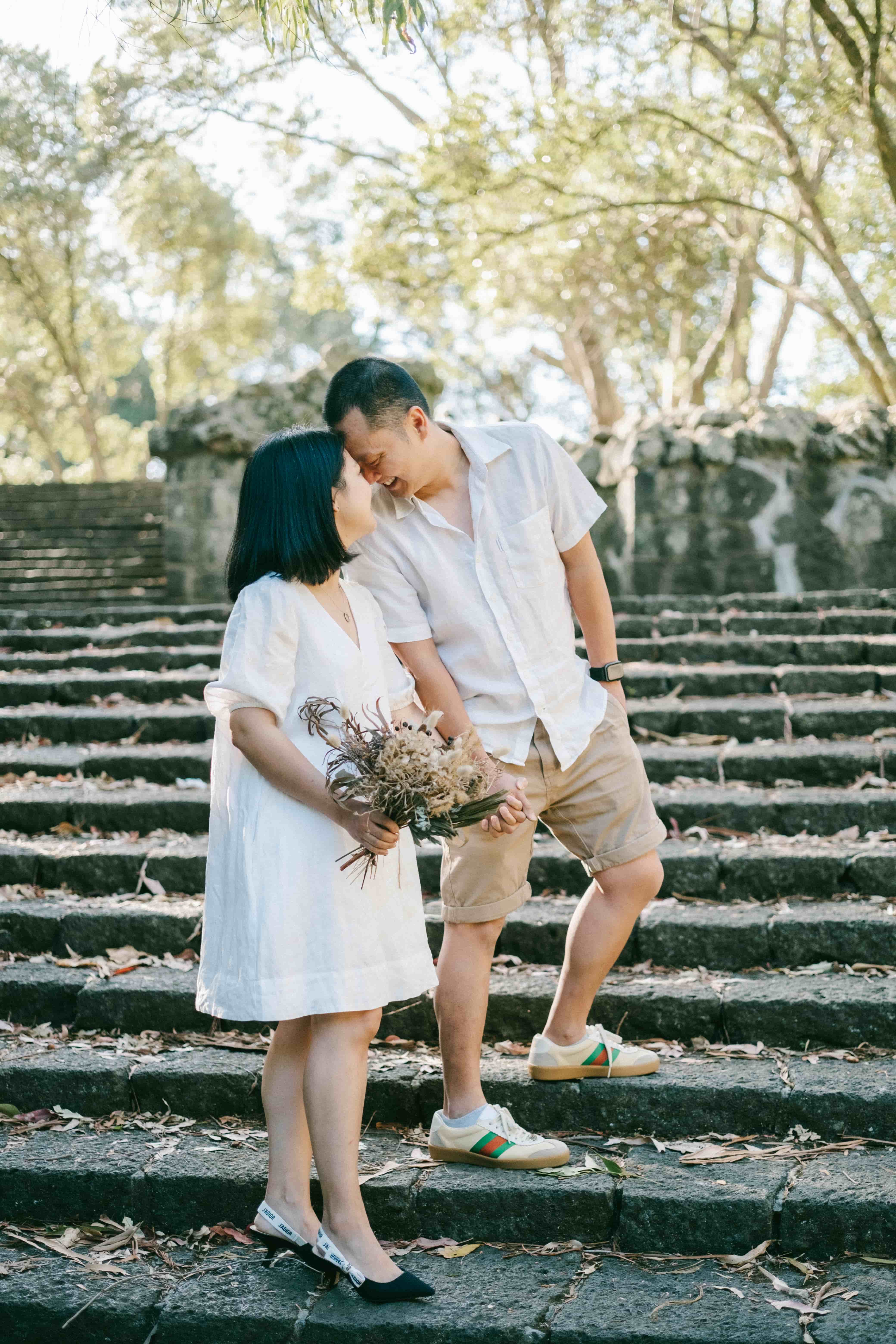 Couple leaning in for a kiss on old stone steps