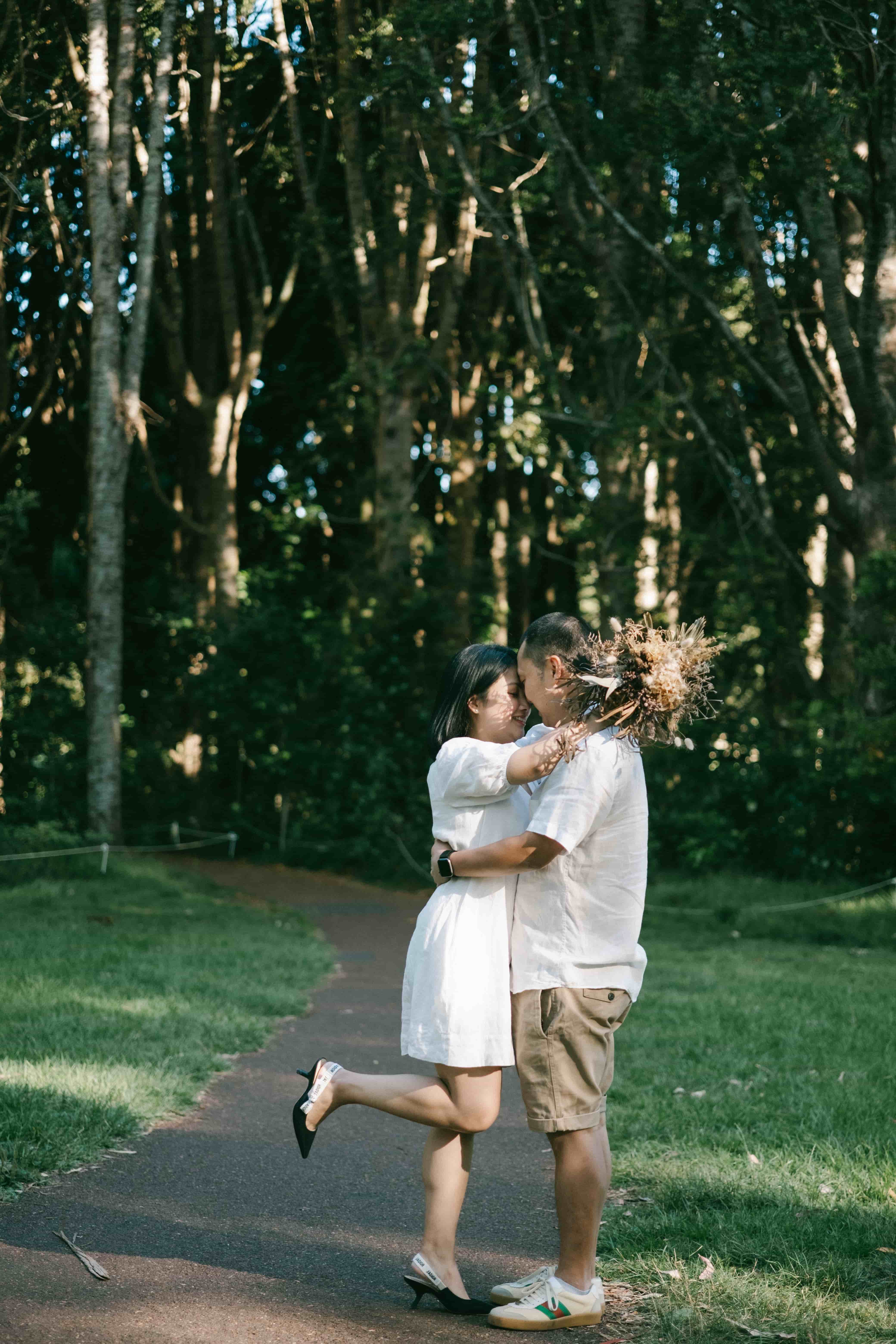 Wife leaping into her husband's arms on a park path