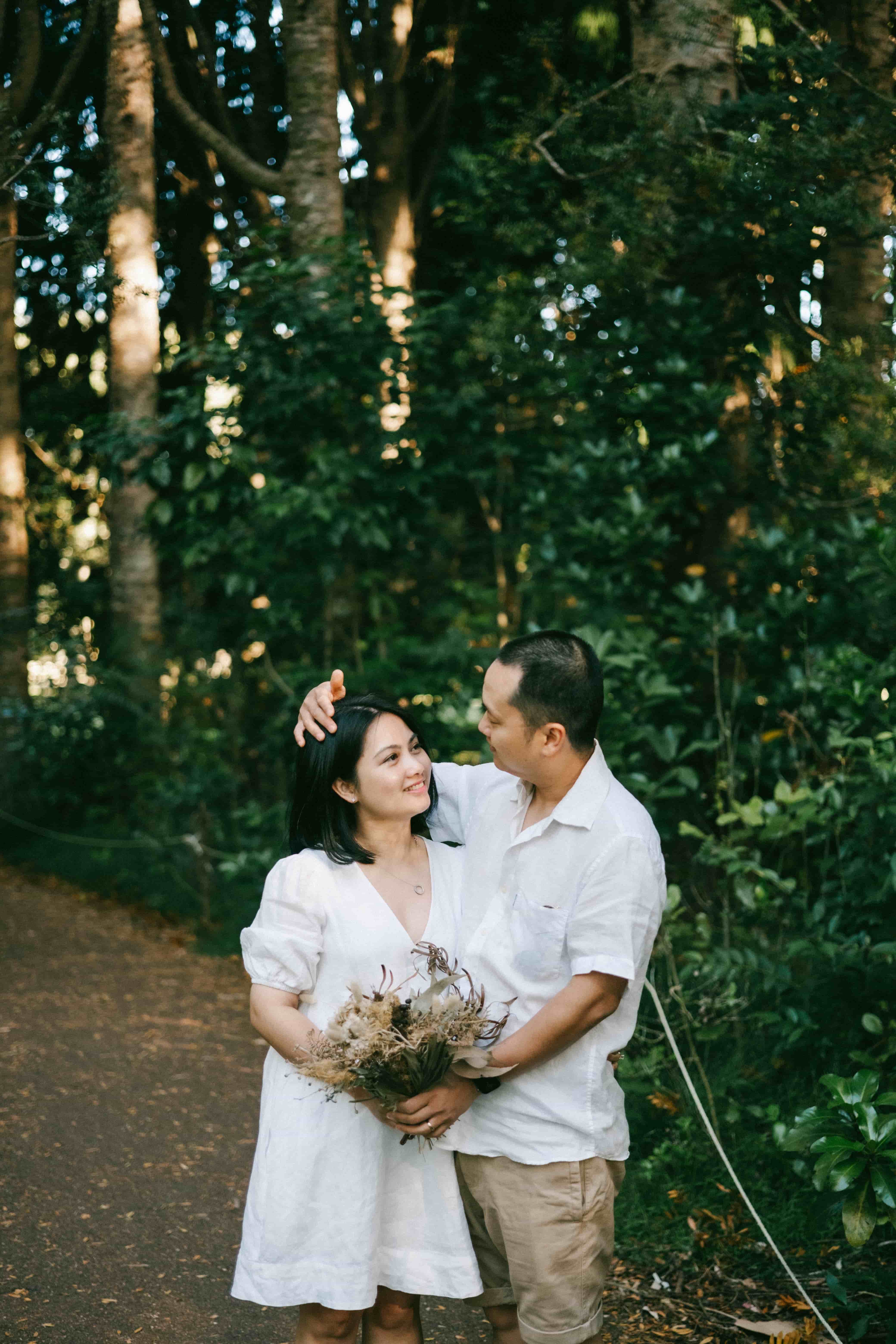 Couple laughing on a bush track, his arm around her