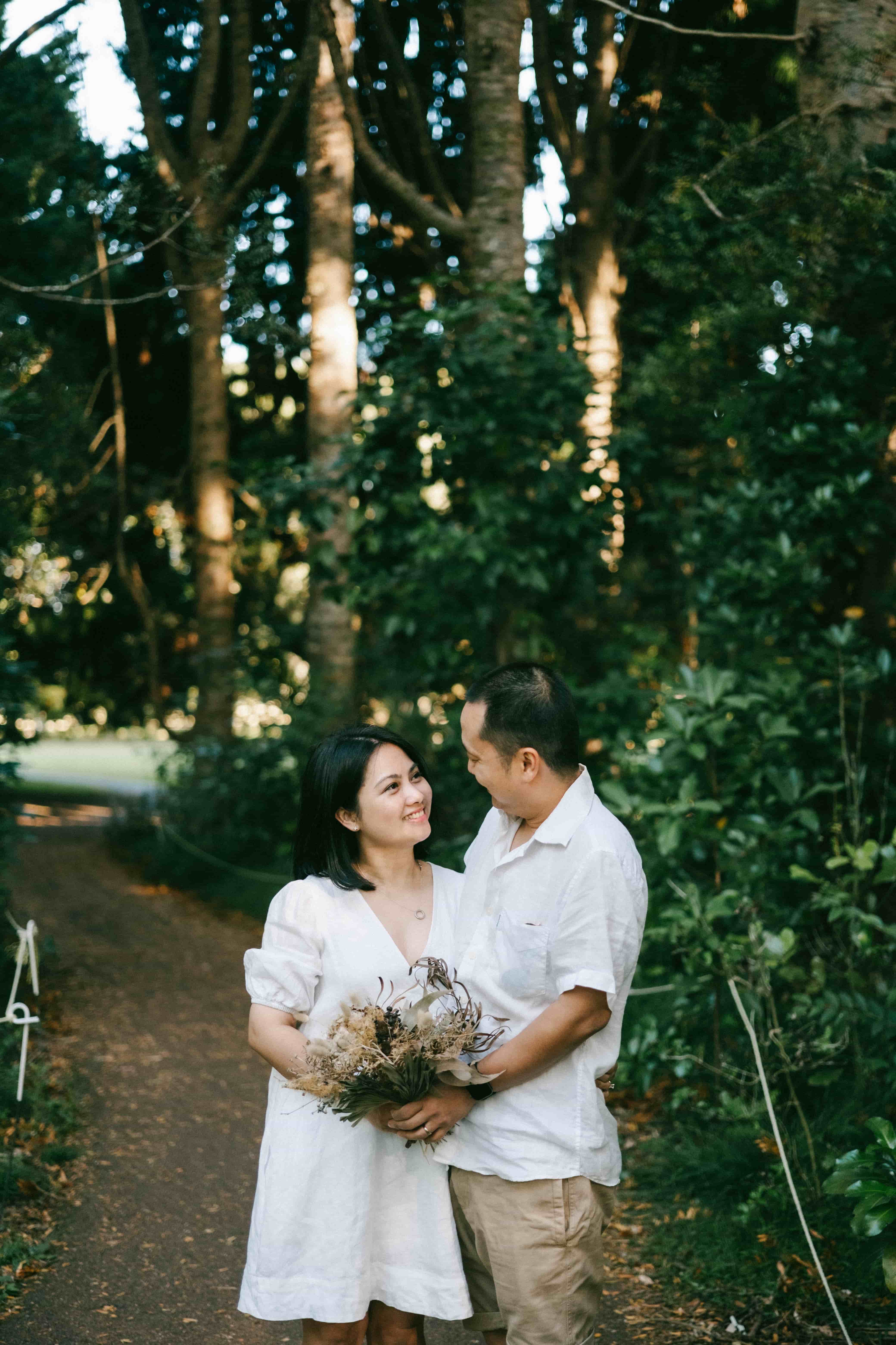 Couple holding the bouquet on a forest path