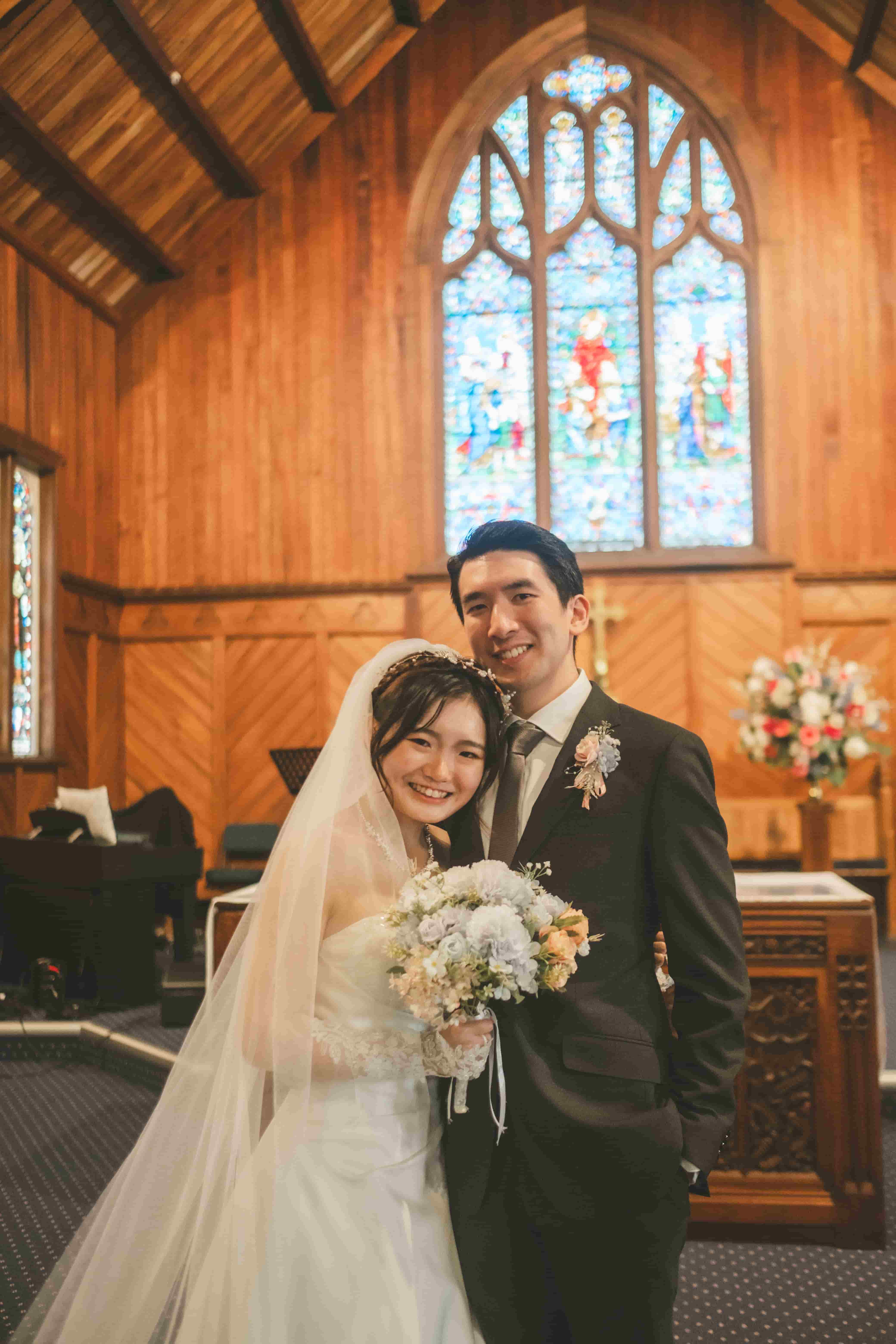 Chrystynn leaning her head on Hans's shoulder inside the warm timber church