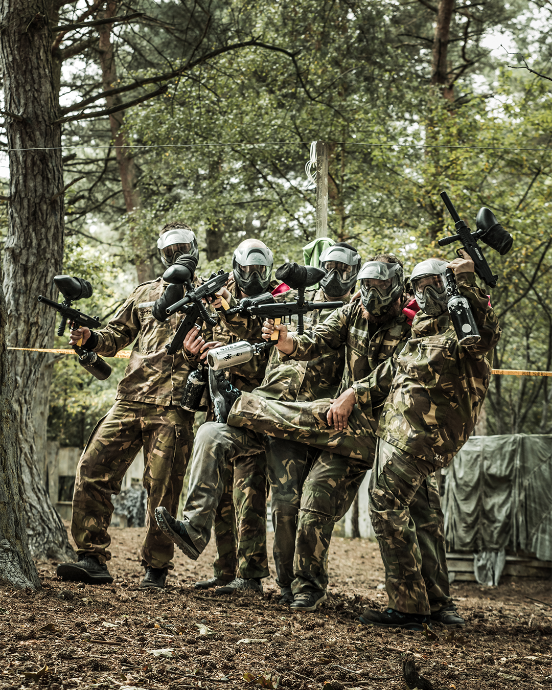 Een blije groep mensen die aan het paintballen zijn.