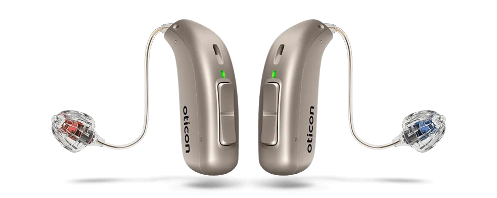 Close-up of Oticon hearing aids in a sleek behind-the-ear design, shown in metallic silver finish