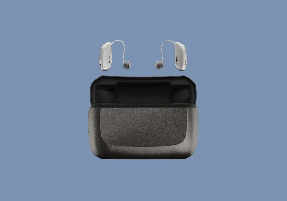Jabra behind-the-ear hearing aids in silver, shown above a black portable charging case on a blue background.