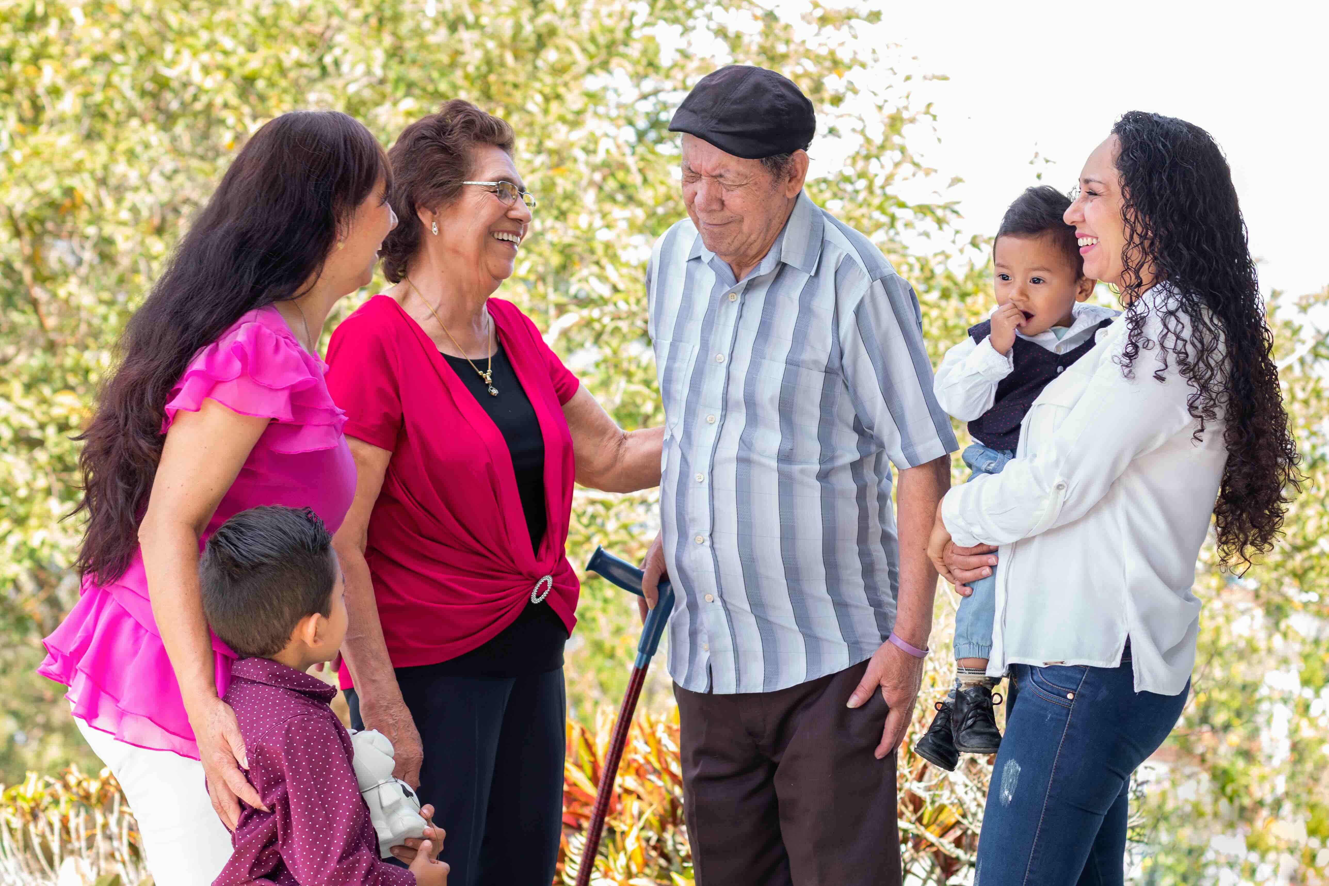 Multigenerational family outdoors sharing time together, symbolizing caregiver meaning and the role of an elderly caregiver while caring for someone across generations.