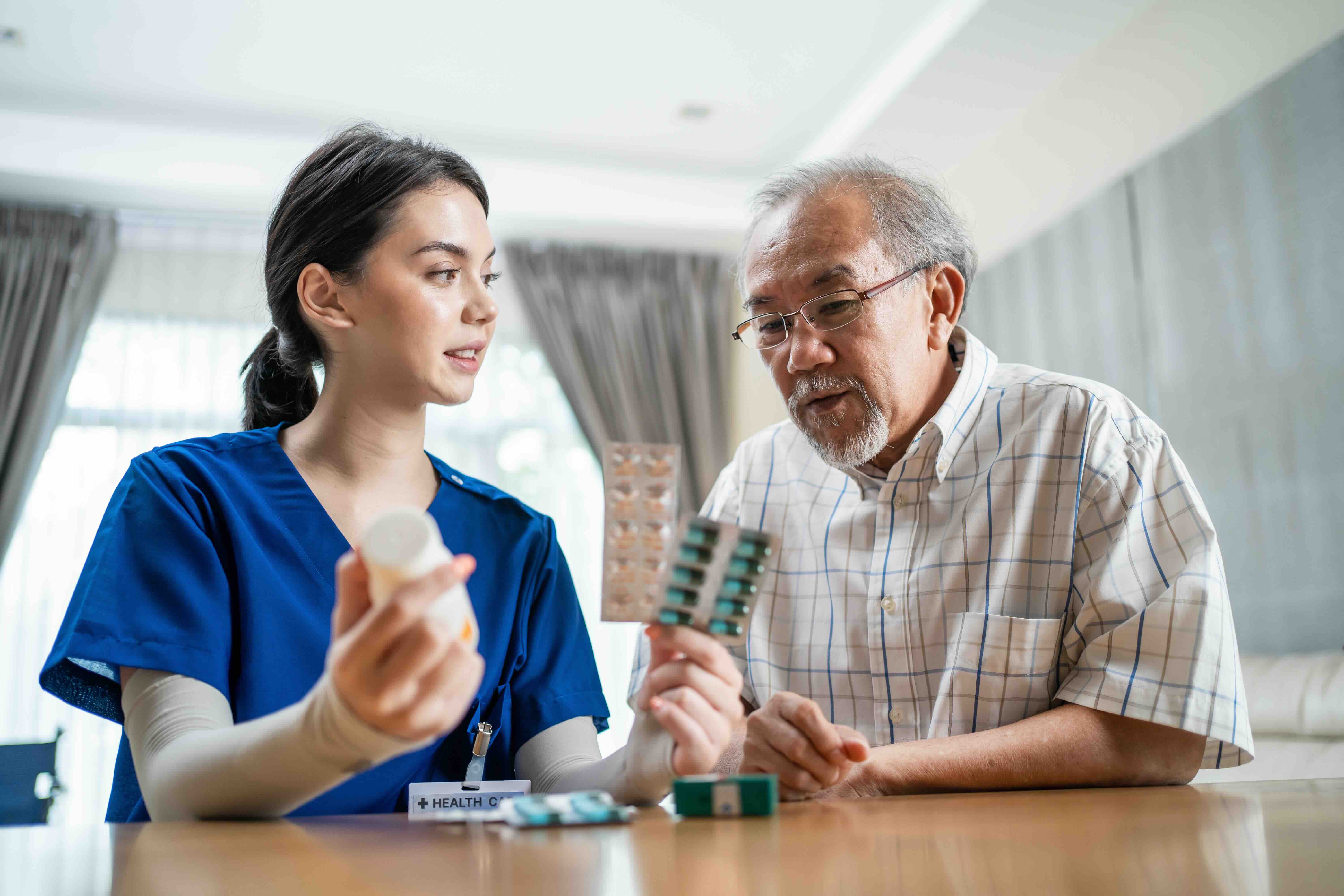 A home health aide reviews medication with an older adult at home, demonstrating daily care tasks that show what does a home health aide do while supporting safety and independence through a home health agency.