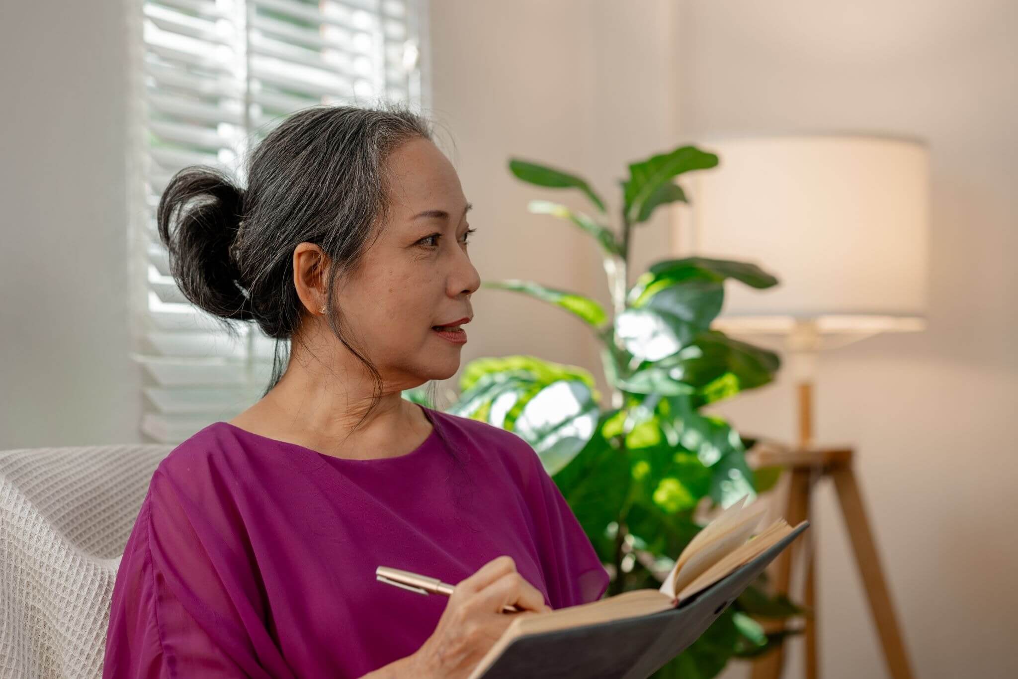 Caregiver reflecting and writing in a journal during the new year, representing thoughtful new year's resolutions and personal time for caregivers focused on balance and emotional well-being.