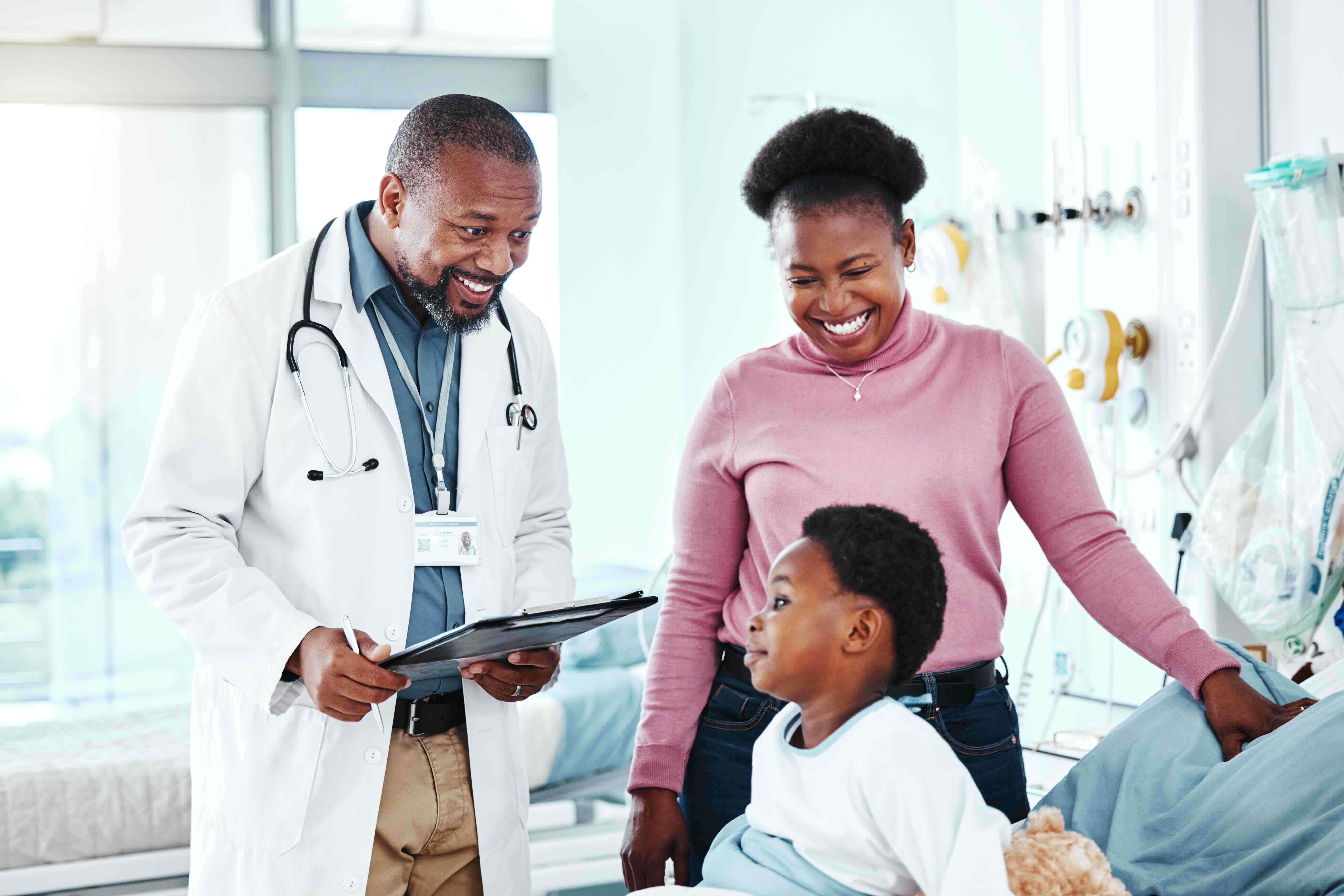 Doctor speaking with a parent and child during a hospital visit, illustrating how families navigate a family emergency with organized records and thoughtful digital document management beyond a traditional emergency kit.