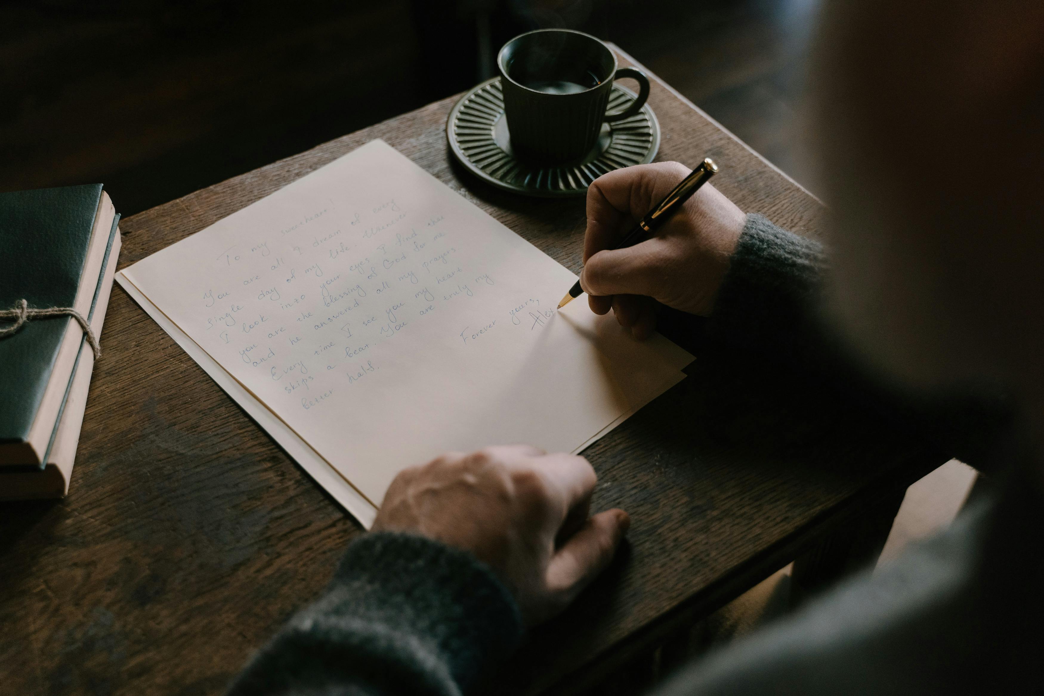 Main d’un senior écrivant une lettre à la main