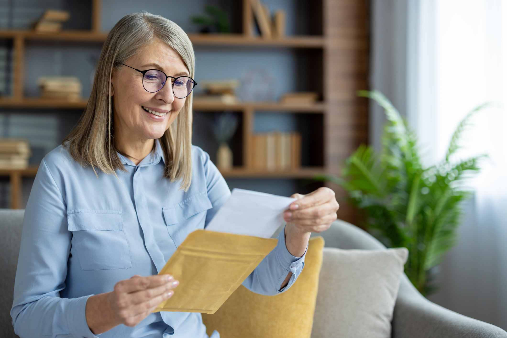 Portrait d’une femme de 65 ans souriante lisant une lettre