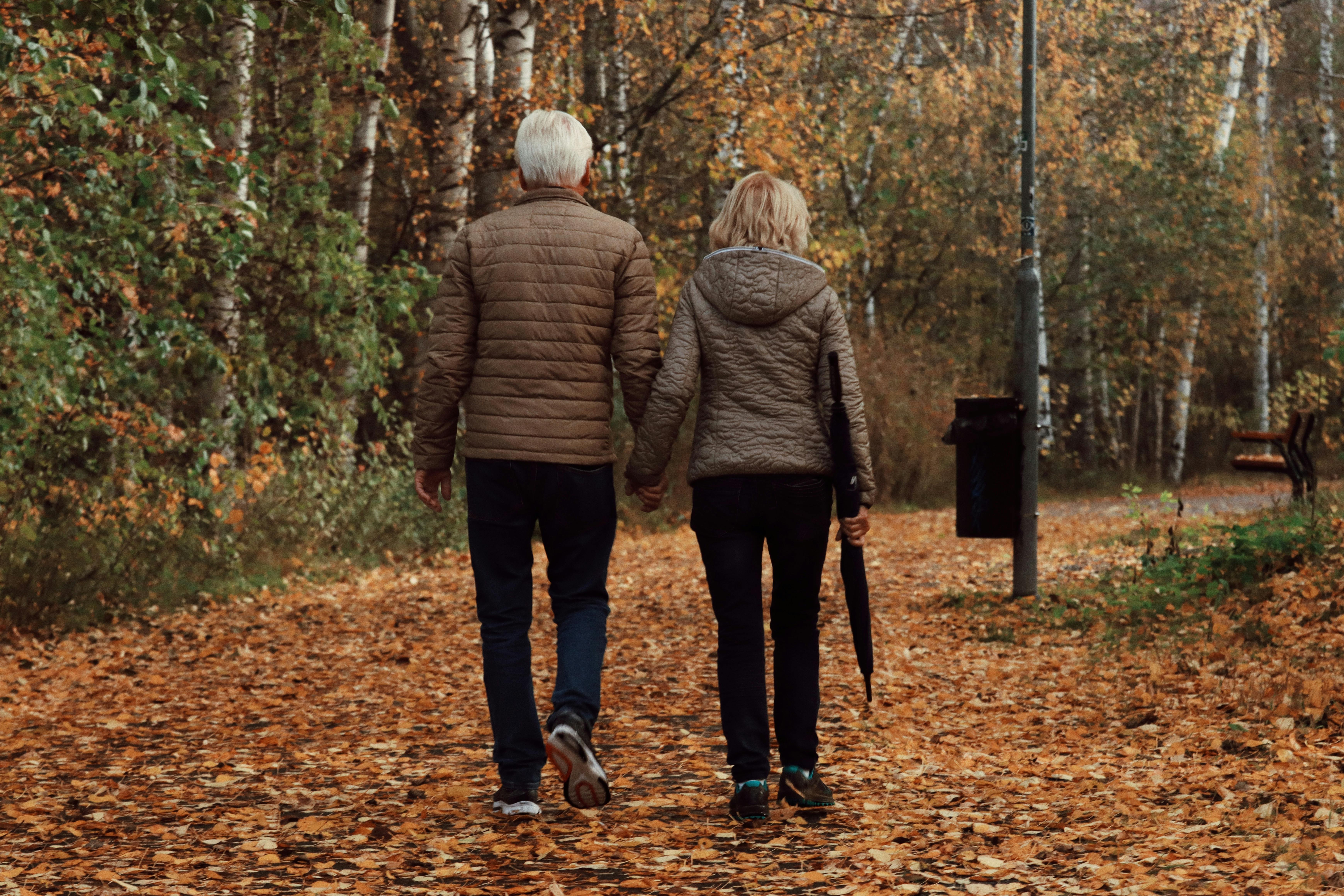Couple senior marchant main dans la main dans un parc