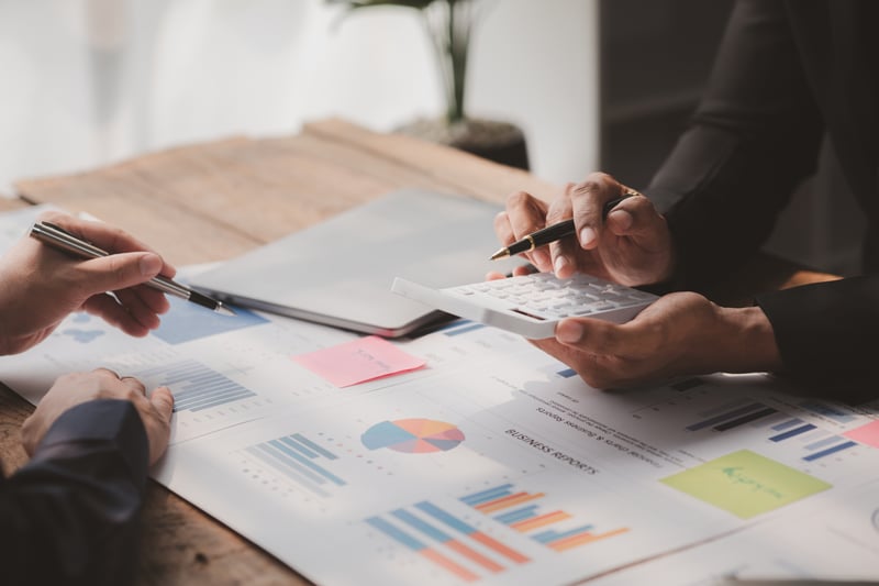 Calculator and financial charts representing executive search costs