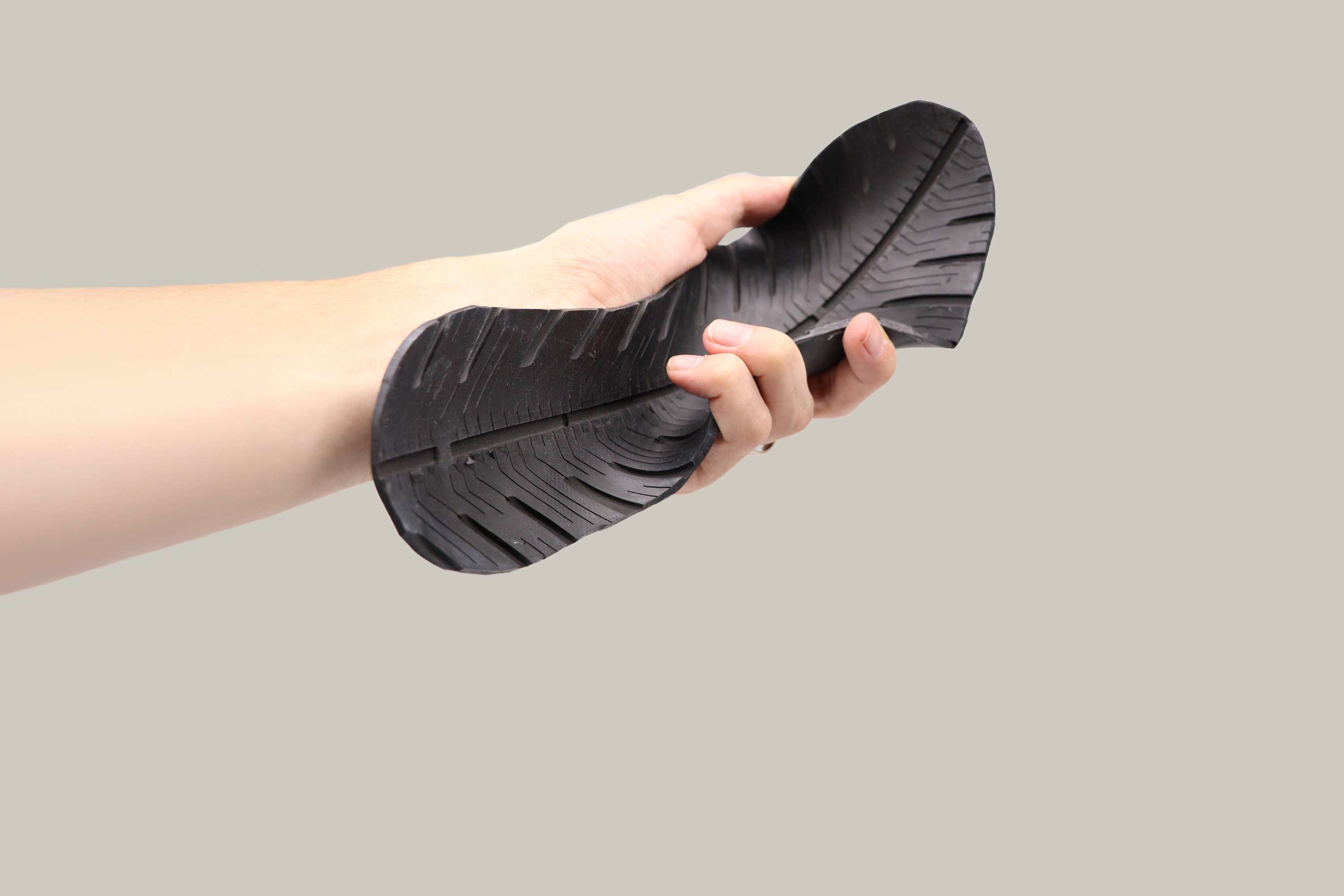 Brazo de un chico mostrando una suela fabricada con las bandas de rodadura de Tiresoul. 