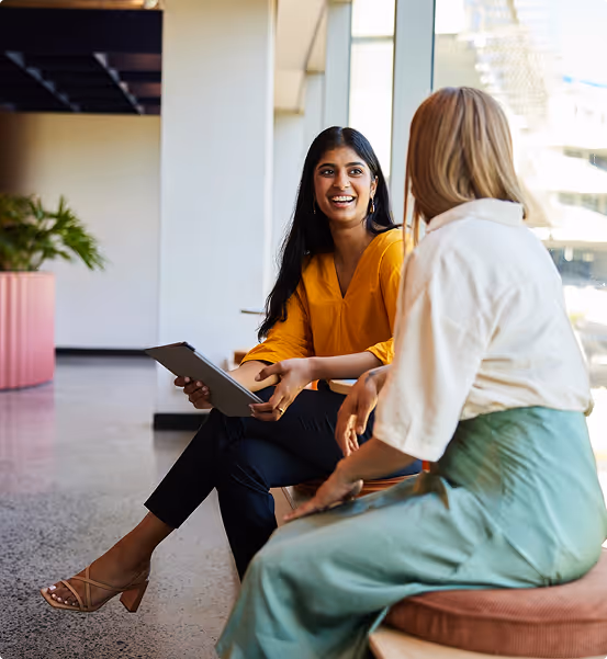 Two women chatting to each other in an office environment