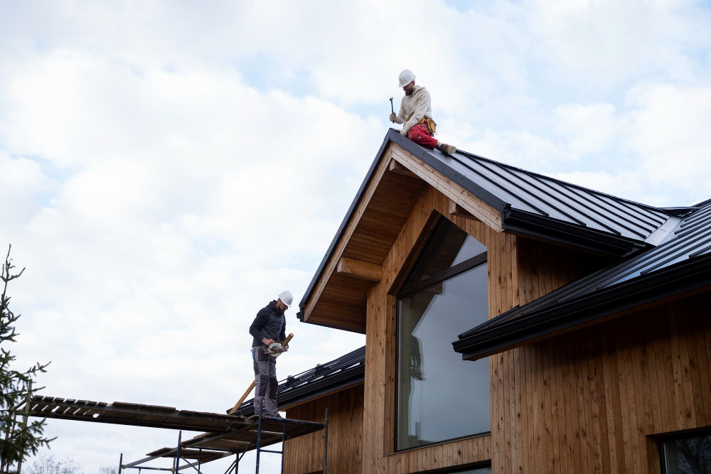 two men fixing roof of large home