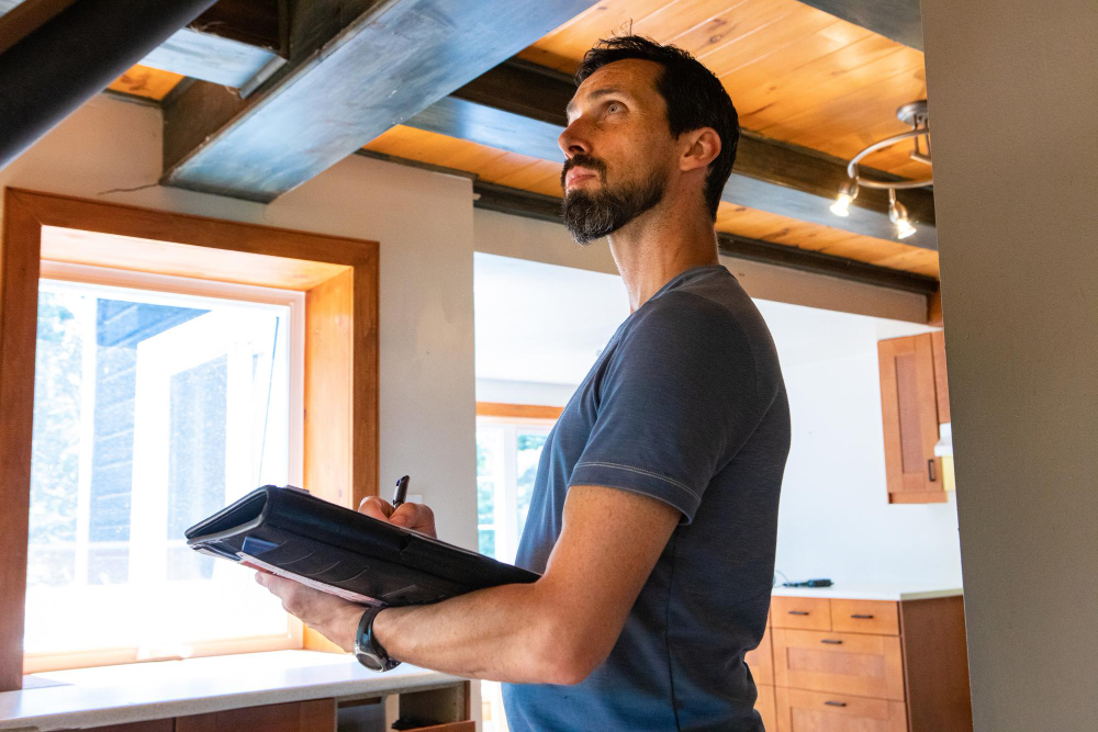 man inspecting home with clipboard