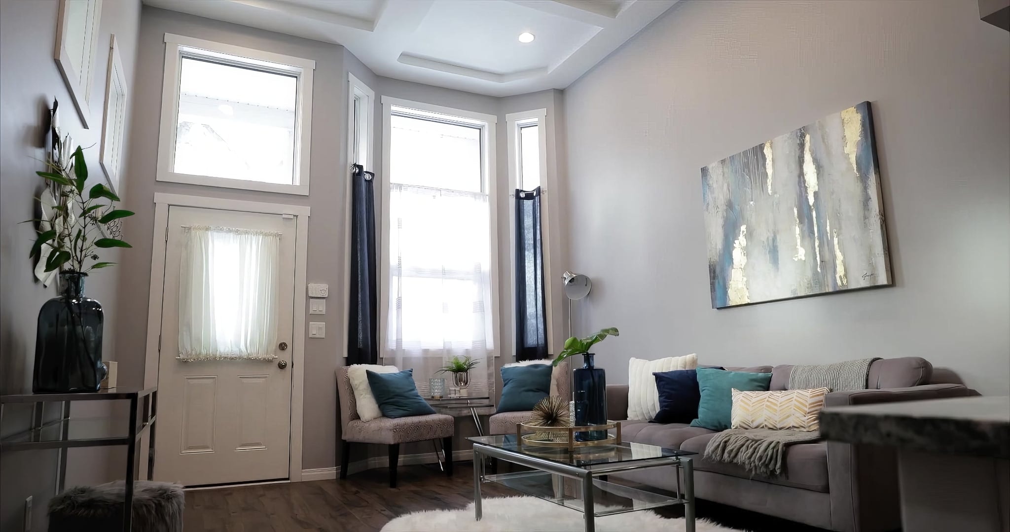 A living room with a couch a table and a painting on the wall
