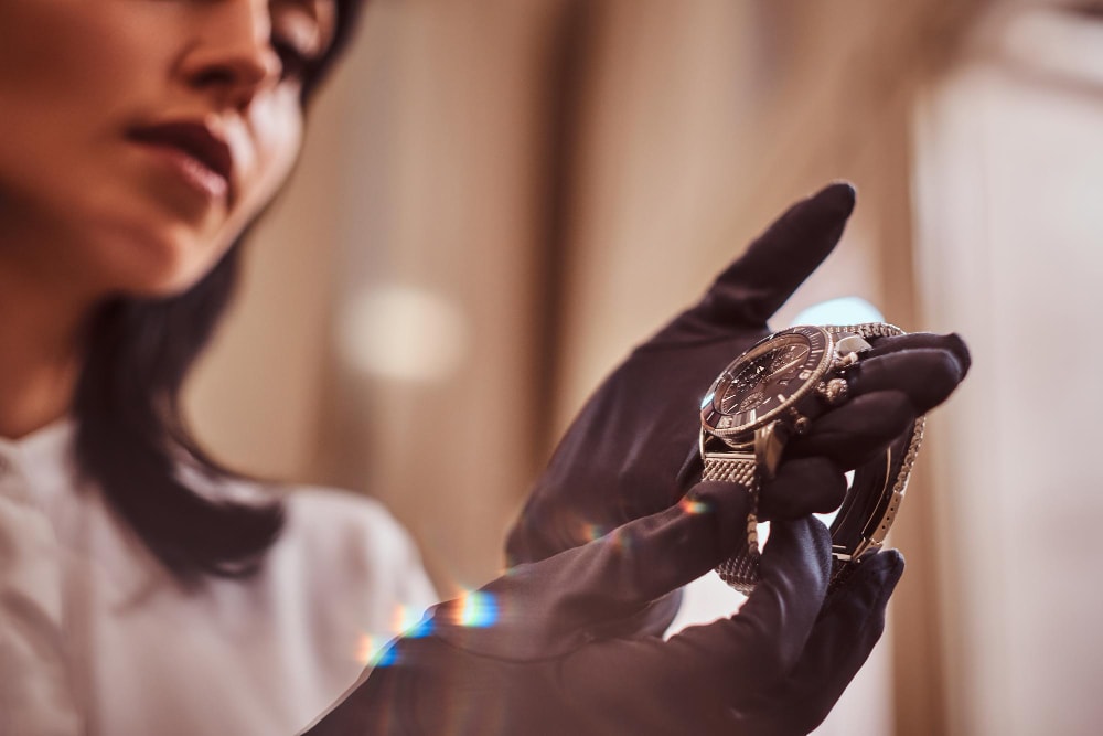 The seller shows an exclusive men's wristwatch from the new collection in the luxury jewelry store