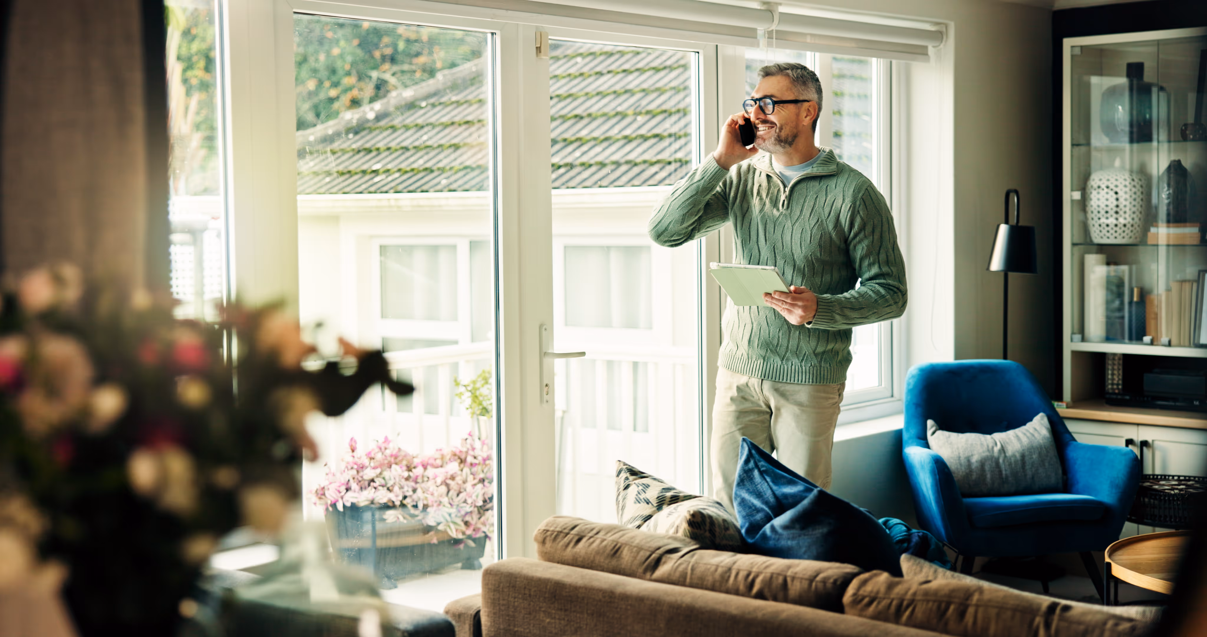 man on phone holding contract in living room