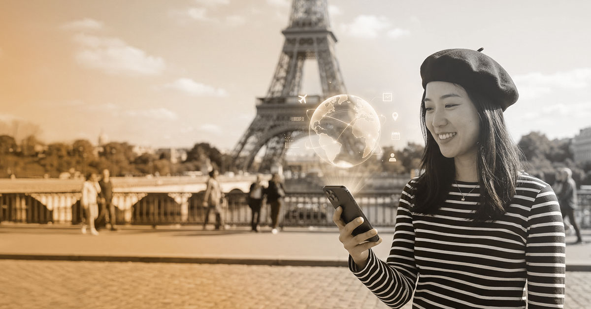 Asiatische Frau mit Handy und dem Hologram einer Weltkugel vor dem Eiffelturm in Paris.