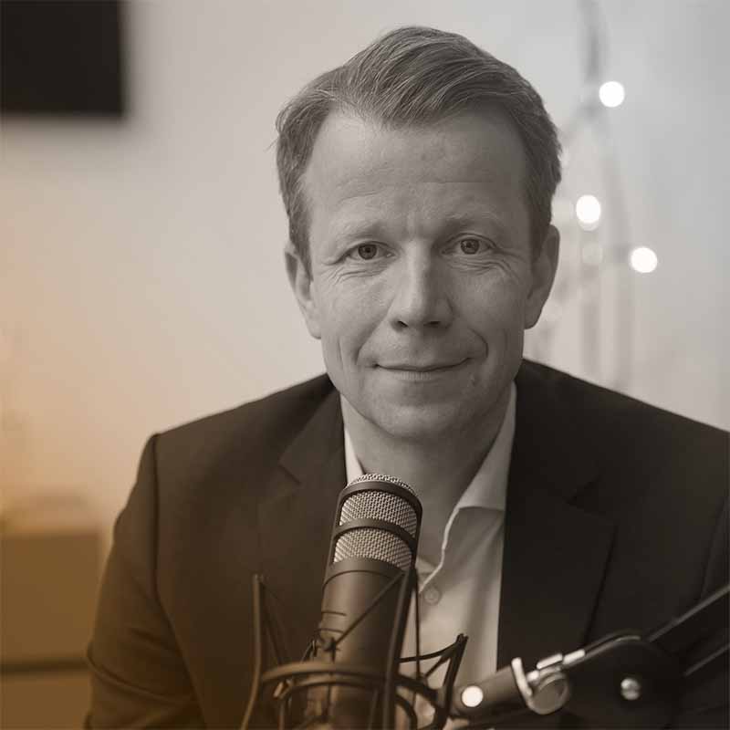 Portraitfoto von Paul Eiselsberg hinter einem Mikrofon