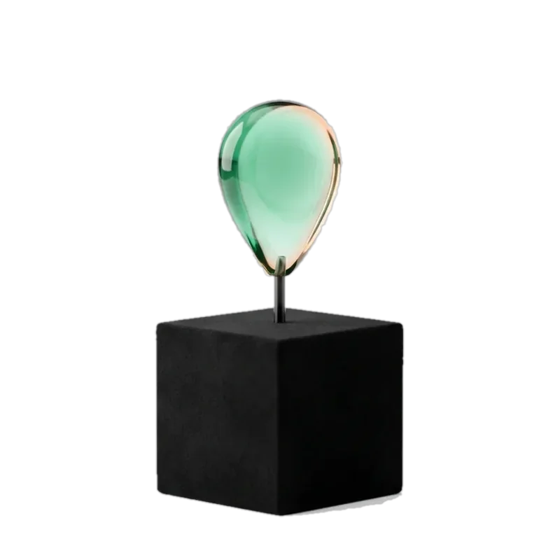 Green glass map pin on a black base