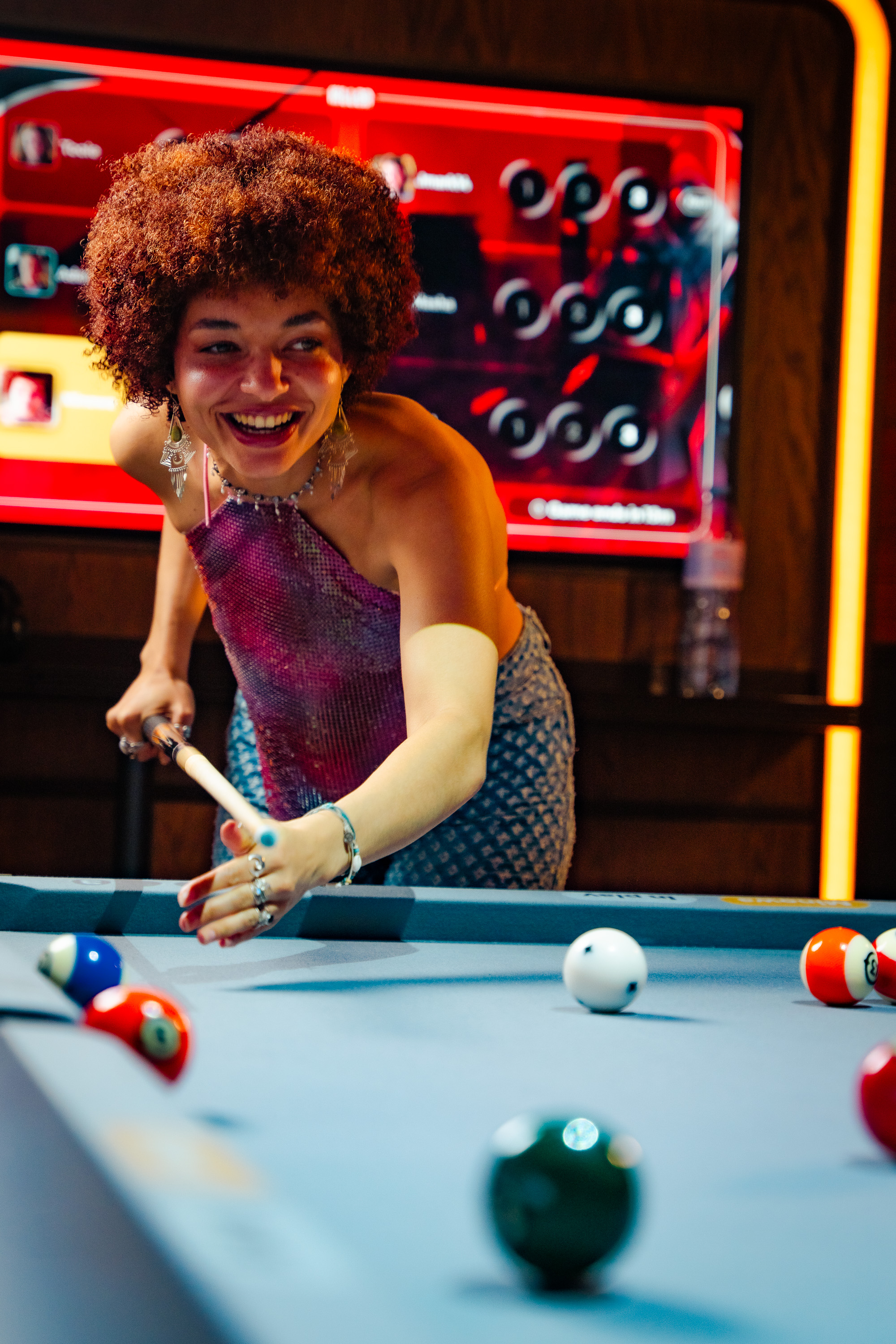 Guests around a lit pool table at Poolhouse