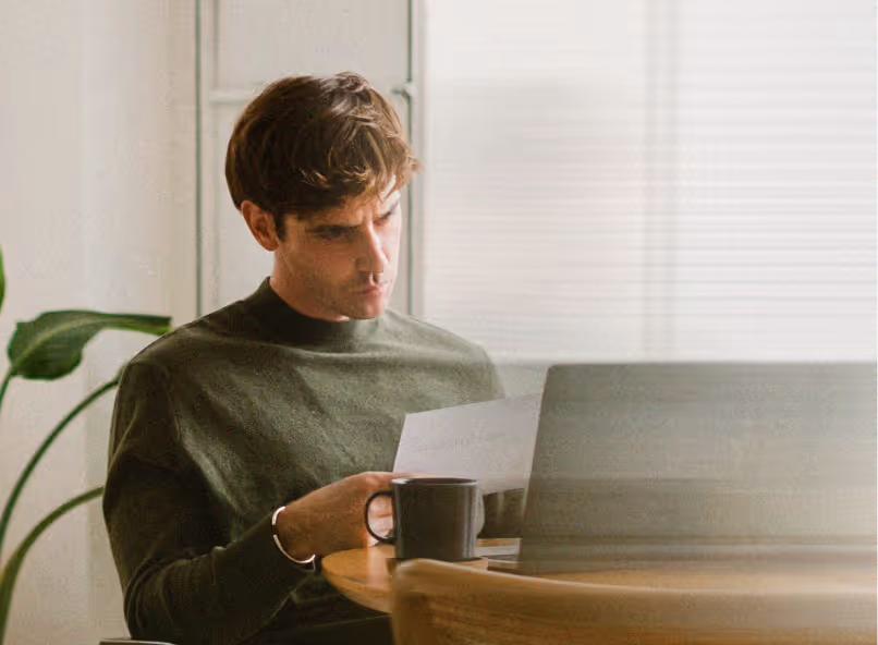 Person working at a desk with laptop and papers, representing founders building a team.