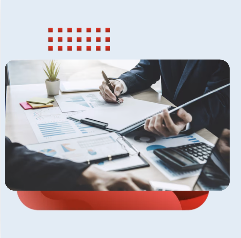 Business professionals sitting at a desk, reviewing financial reports, and charts
