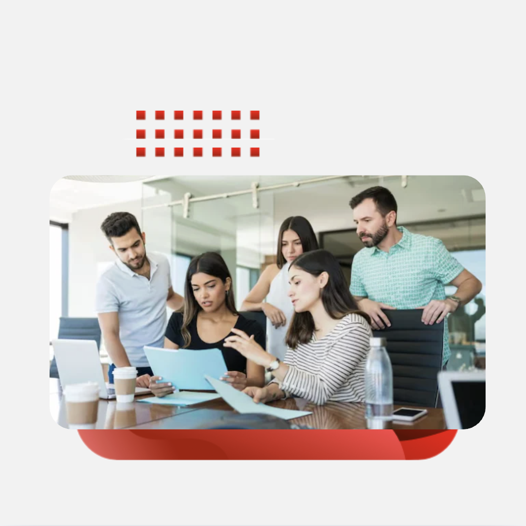 A group of  office professionals gathering around a meeting desk to review files and streamline operations.